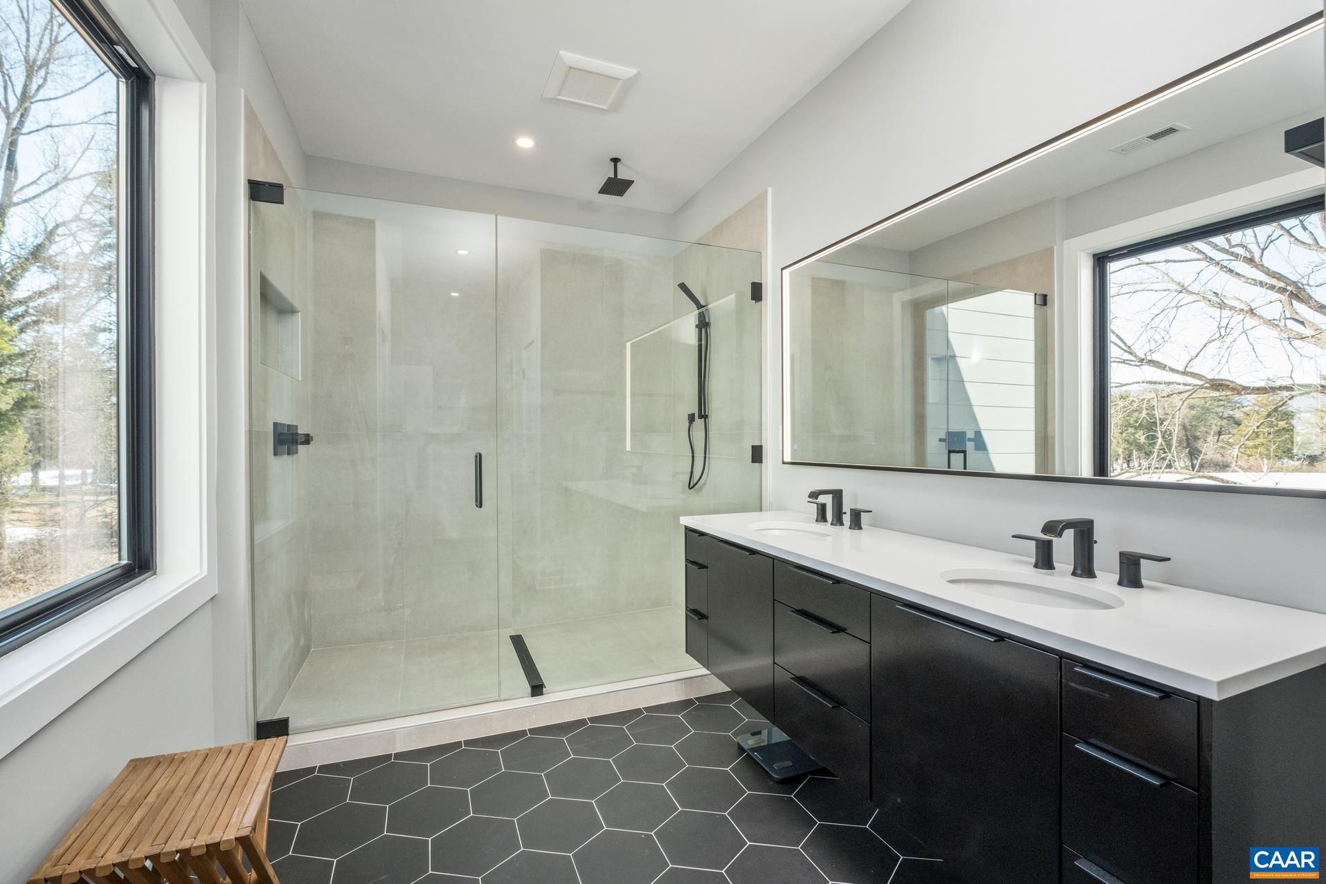 Primary bathroom features large double sink vanity, and frameless glass walk-in shower.  Beautiful tile floor too!