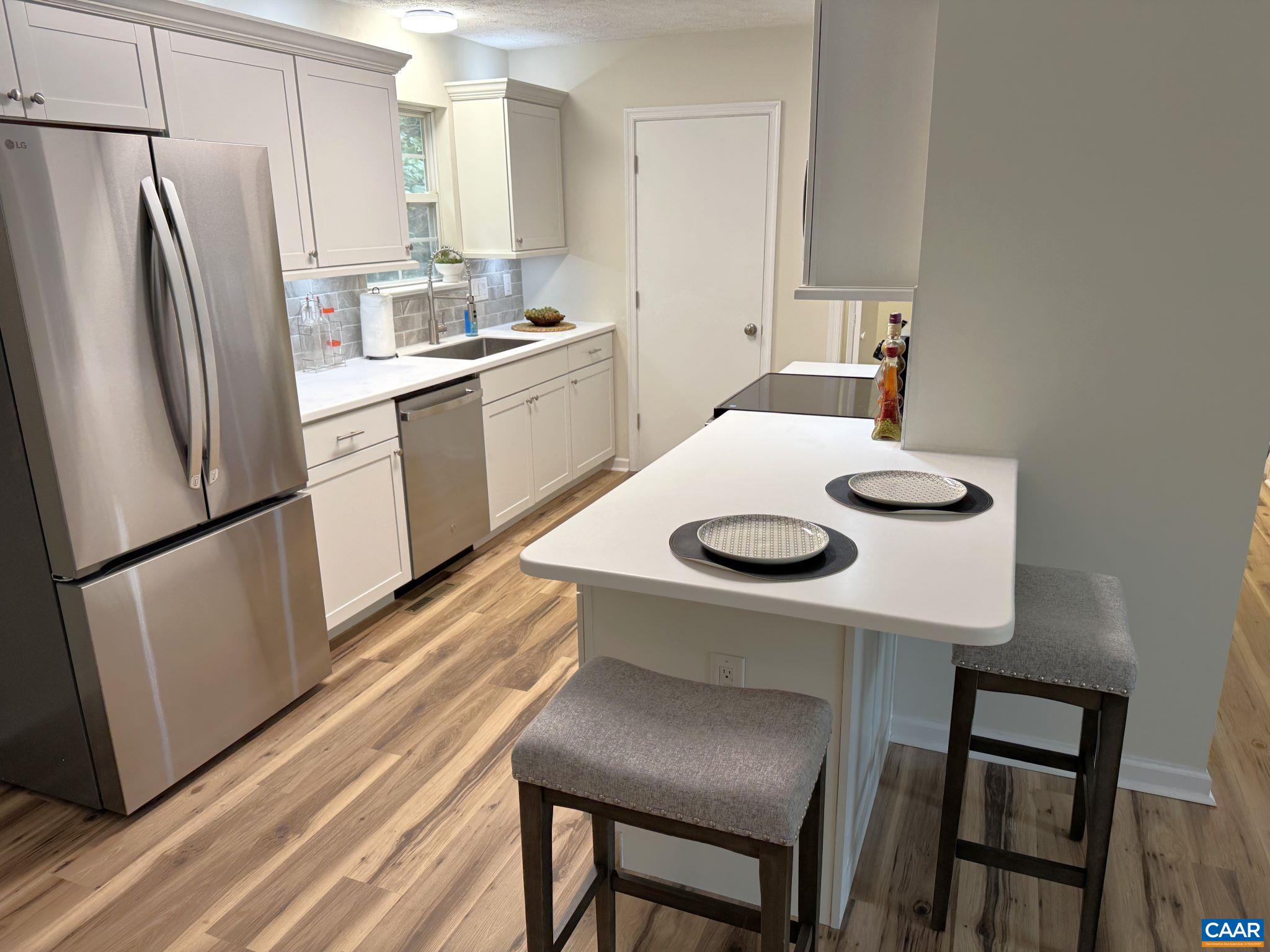 Shaker Cabinets, Solid Surface Counters, Breakfast Bar, Tile Backsplash, Stainless Appliances