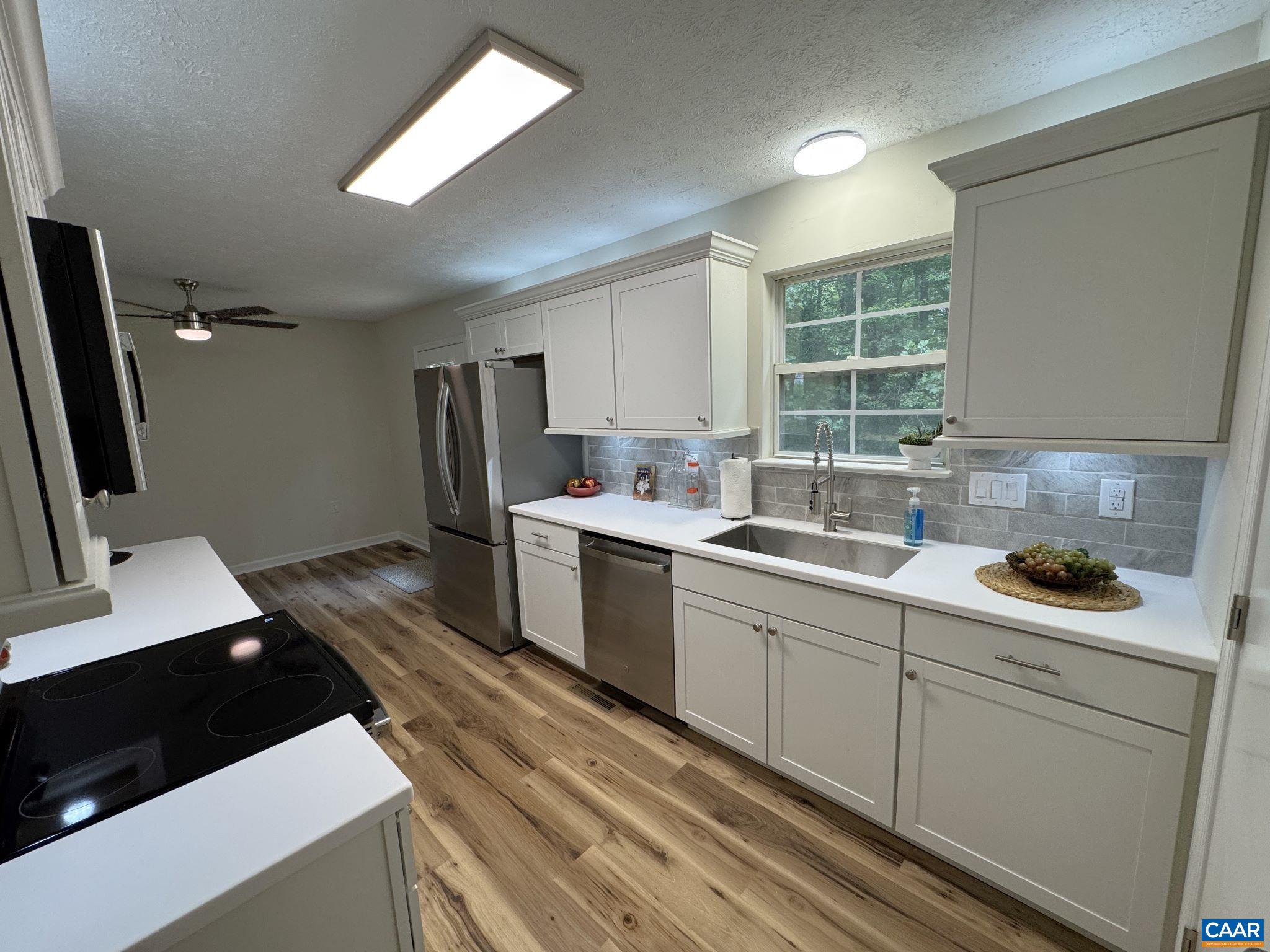 ...with Shaker Cabinets Solid Surface Counters, Breakfast Bar, Tile Backsplash, Stainless Appliances, Eat-in Dining Area