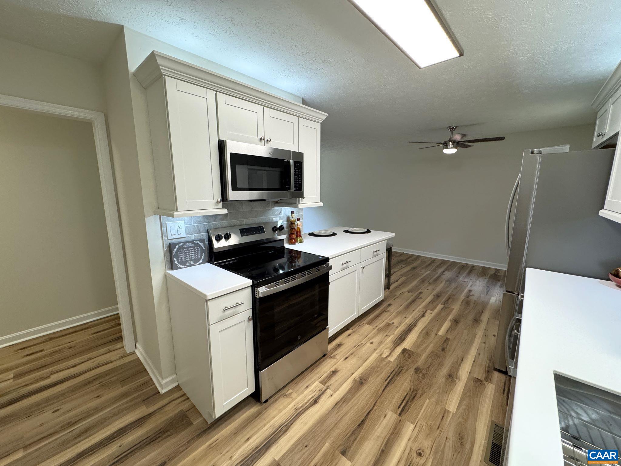 Another View with Shaker Cabinets Solid Surface Counters, Breakfast Bar, Tile Backsplash,  Stainless Appliances with Eat-in Dining Area