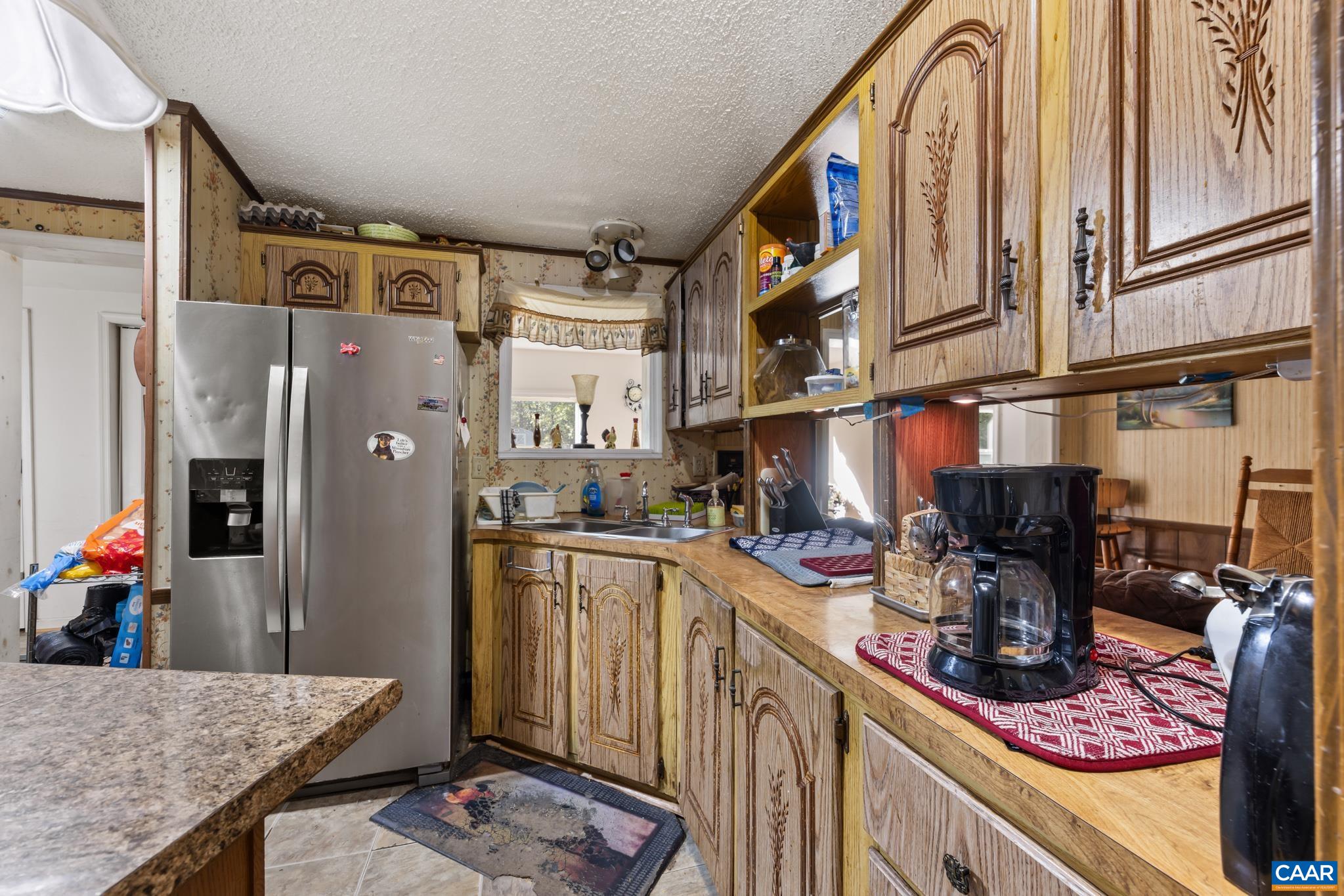 Enjoy classic country charm in this spacious kitchen! Featuring generous counter space, classic wood cabinetry, an eye-level oven, and a cozy dining peninsula, it offers a warm, functional hub with fantastic storage and prep space. No dishwasher. Enjoy classic country charm in this spacious kitchen! Featuring generous counter space, classic wood cabinetry, an eye-level oven, and a cozy dining peninsula, it offers a warm, functional hub with fantastic storage and prep space. No dishwasher.