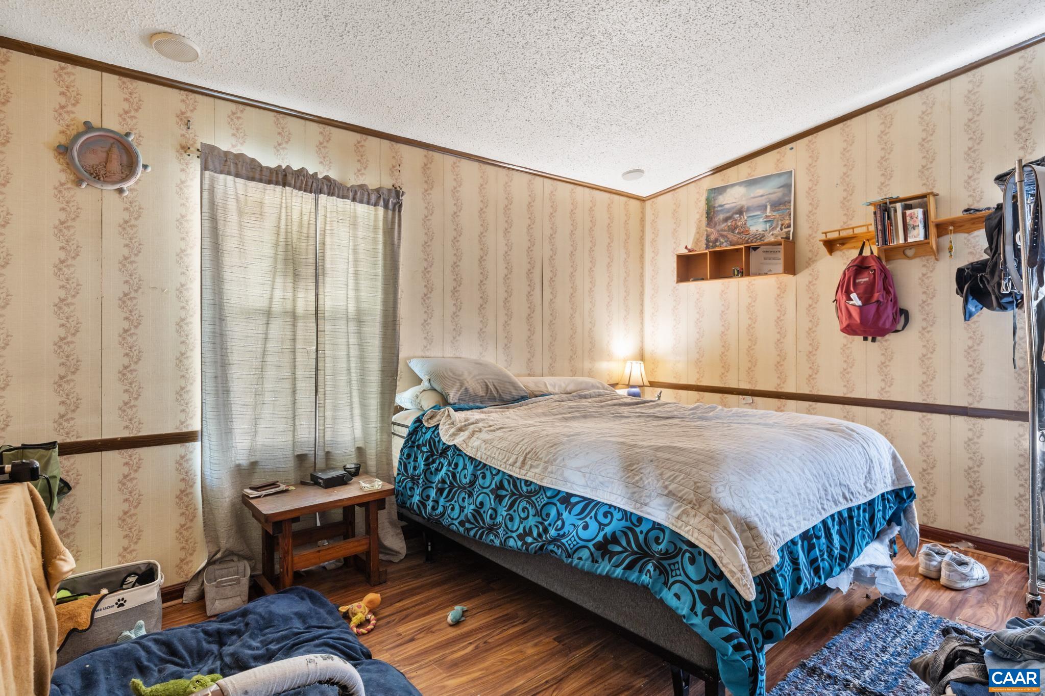 Unwind in this comfortable 2nd primary bedroom! Featuring warm wood-look flooring, classic paneled walls, bright natural light, this cozy retreat offers a peaceful space for family, guests, or a dedicated home office. Modern comfort meets classic charm! Unwind in this comfortable 2nd primary bedroom! Featuring warm wood-look flooring, classic paneled walls, bright natural light, this cozy retreat offers a peaceful space for family, guests, or a dedicated home office. Modern comfort meets classic charm!