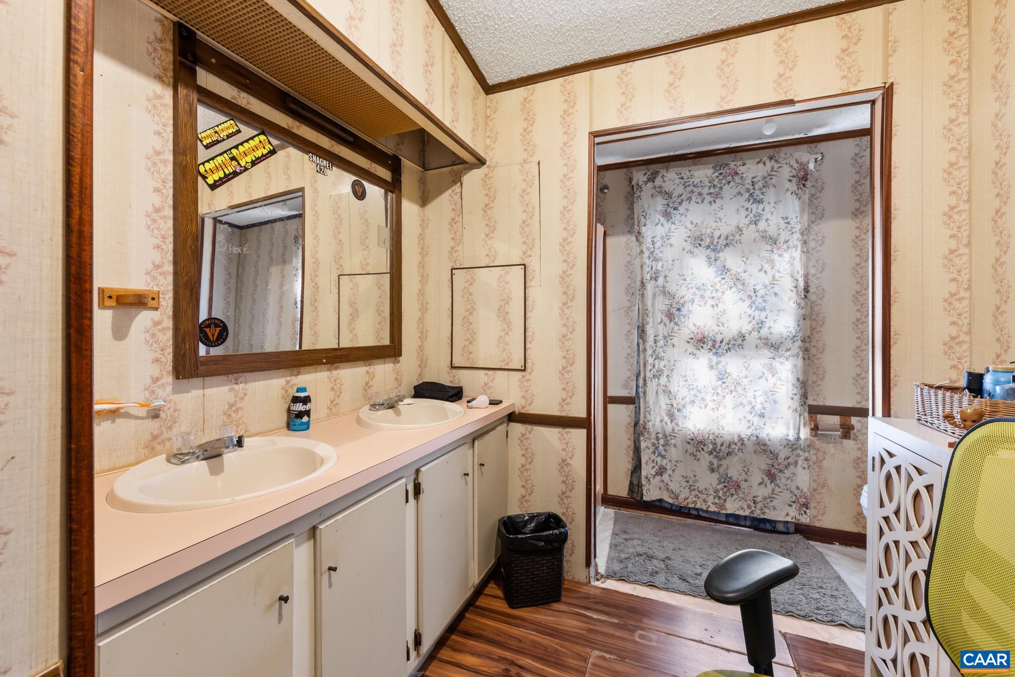 Relax in this spacious ensuite bathroom adjacent to the 2nd bedroom! Featuring a broad double-sink vanity, expansive mirror, wood-look flooring, and a walk-in shower with glass enclosure, this bright space blends functional storage with total comfort. Relax in this spacious ensuite bathroom adjacent to the 2nd bedroom! Featuring a broad double-sink vanity, expansive mirror, wood-look flooring, and a walk-in shower with glass enclosure, this bright space blends functional storage with total comfort.