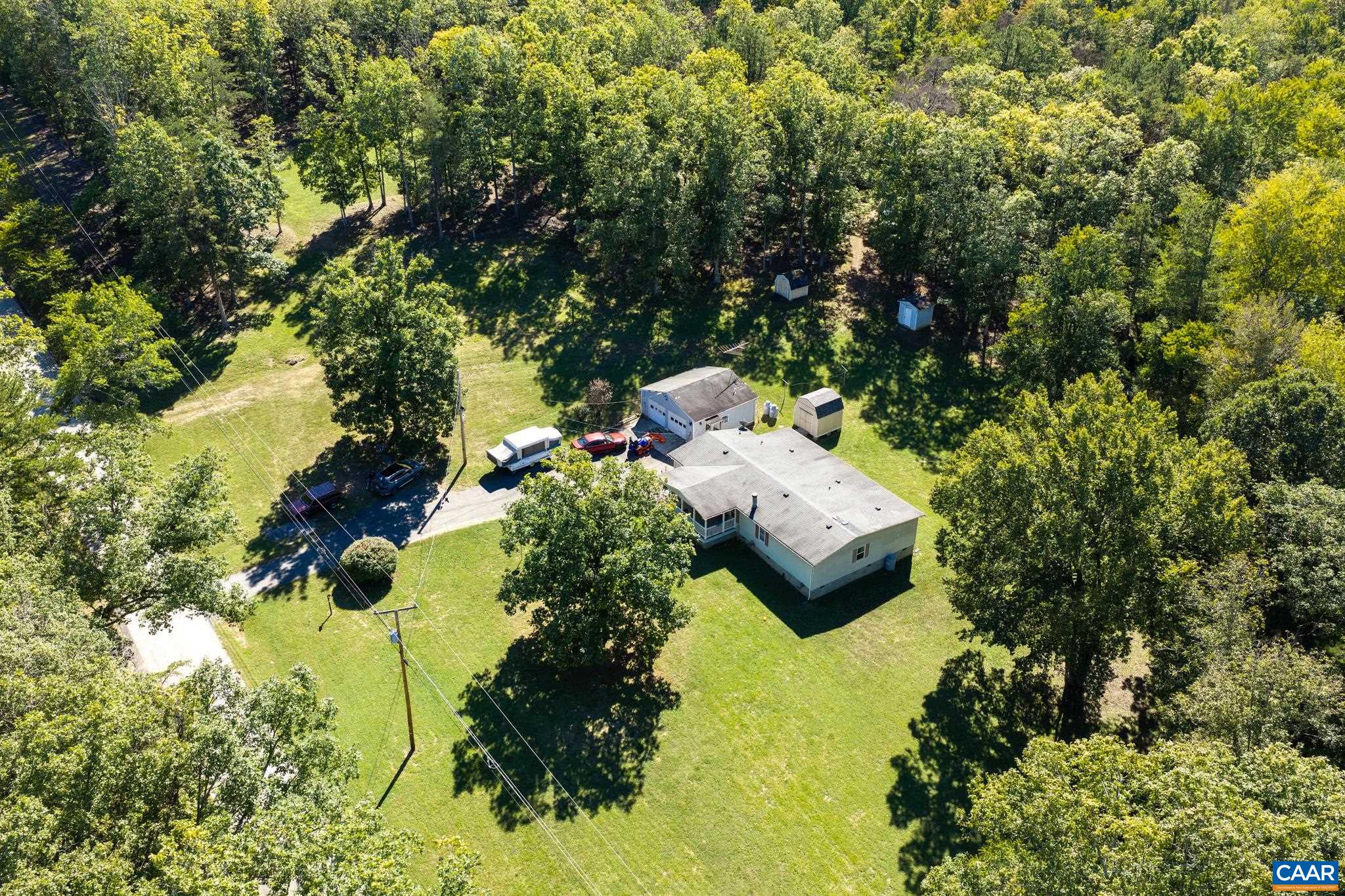 An aerial view highlights the expansive privacy of this 1,891 sq ft home! Nestled on 2 lots totaling 6.73 acres, the property features a vast lush lawn, mature trees, and endless outdoor space for ultimate tranquility and potential. An aerial view highlights the expansive privacy of this 1,891 sq ft home! Nestled on 2 lots totaling 6.73 acres, the property features a vast lush lawn, mature trees, and endless outdoor space for ultimate tranquility and potential.
