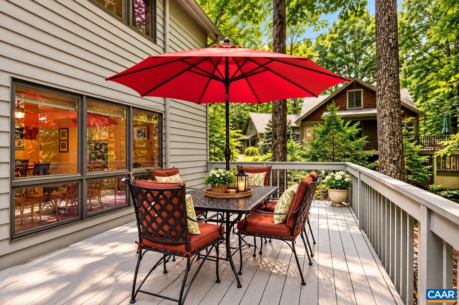 Step outside to an expansive deck spanning the entire back of the home—the perfect spot to relax, entertain, and enjoy the peaceful wooded setting and views toward the golf fairway.