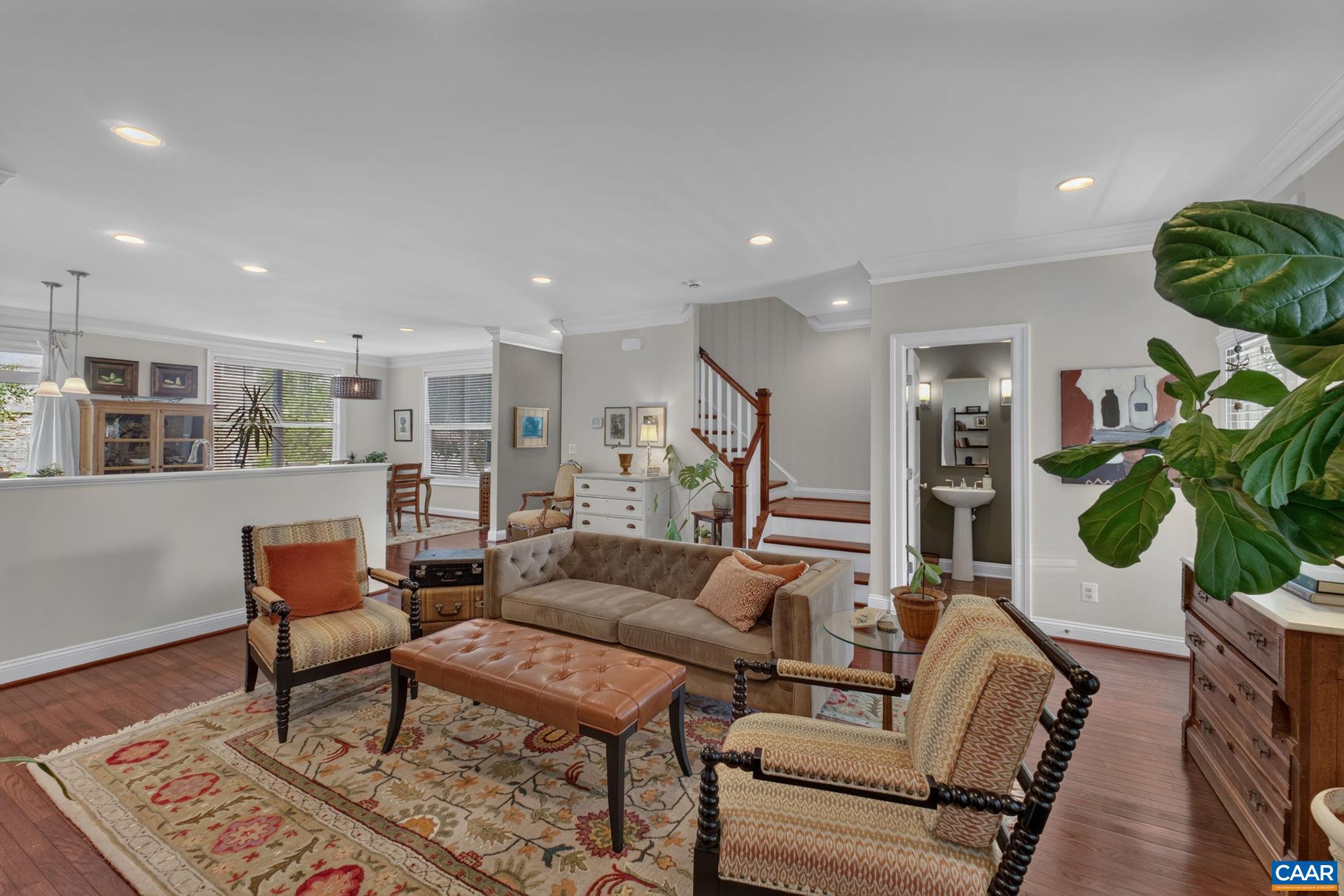 Living room with main level half bath and stairs leading up. Living room with main level half bath and stairs leading up.