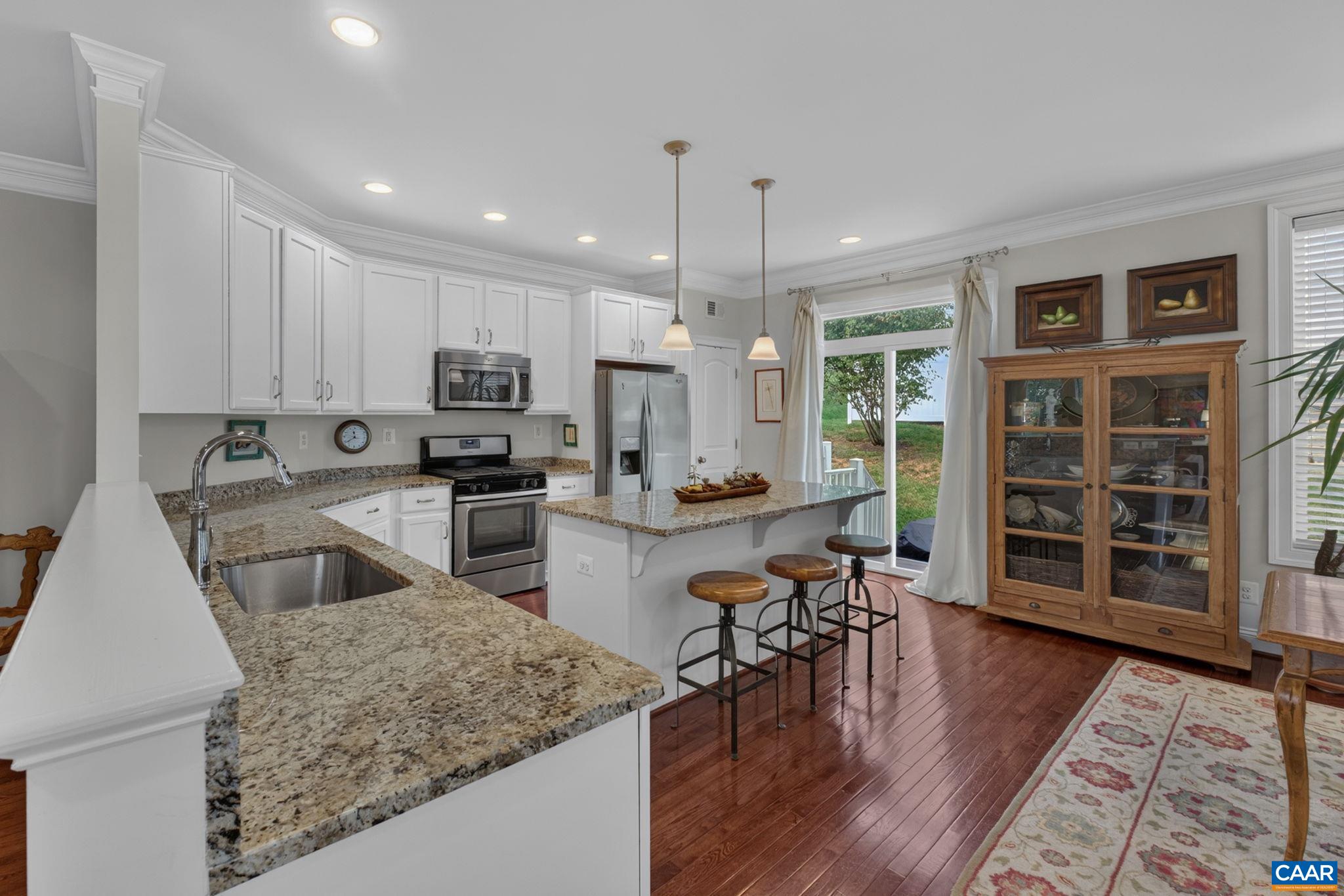 Granite counters and a large kitchen island, and doors leading to the back patio. Granite counters and a large kitchen island, and doors leading to the back patio.