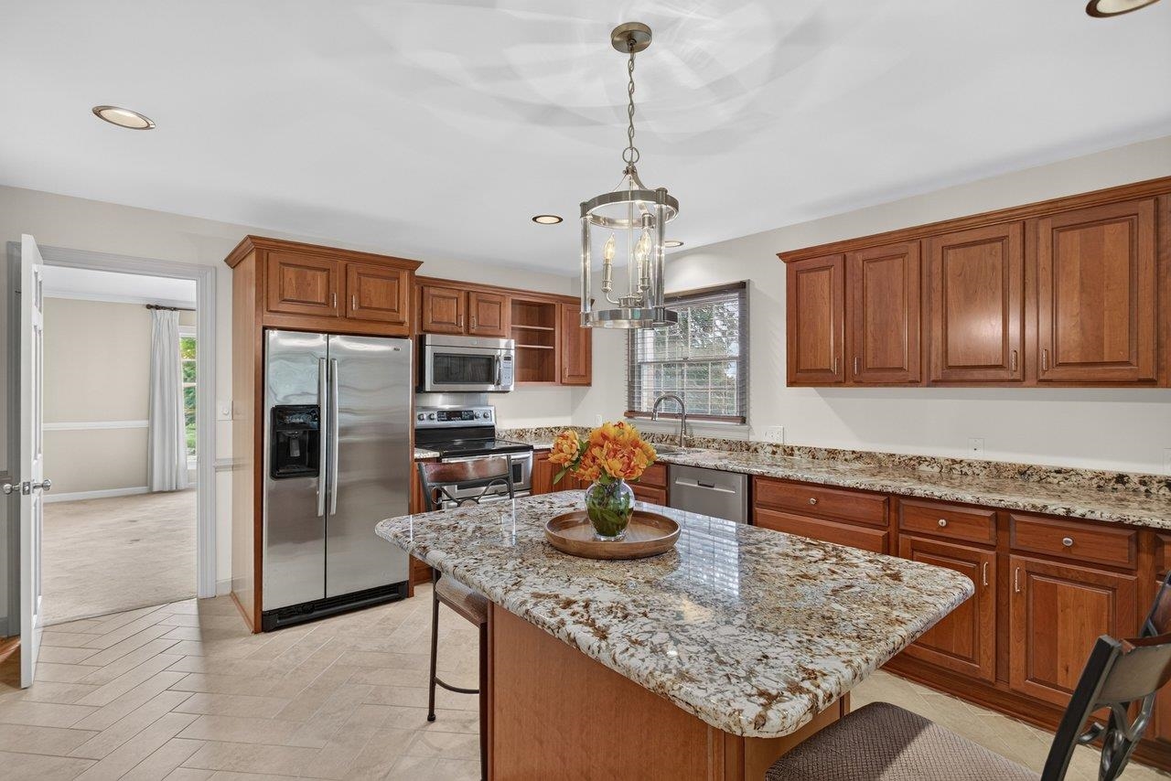 The center island comfortably seats 4. The counter tops are granite, the appliances are stainless steel , the floor is tiled and the cabinetry is solid cherry.