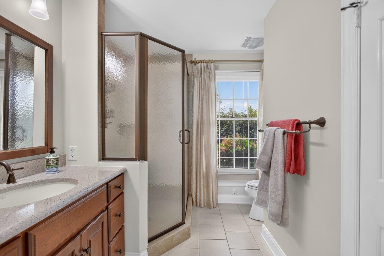 The walk-in shower is fully tiled. The vanity tops are quartzite and this part of the bathroom has a tile floor