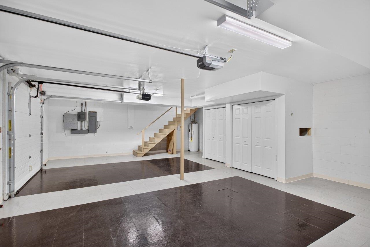 This double car garage has automatic door openers, a refurbished floor, and a large work bench and is ducted for heating and cooling