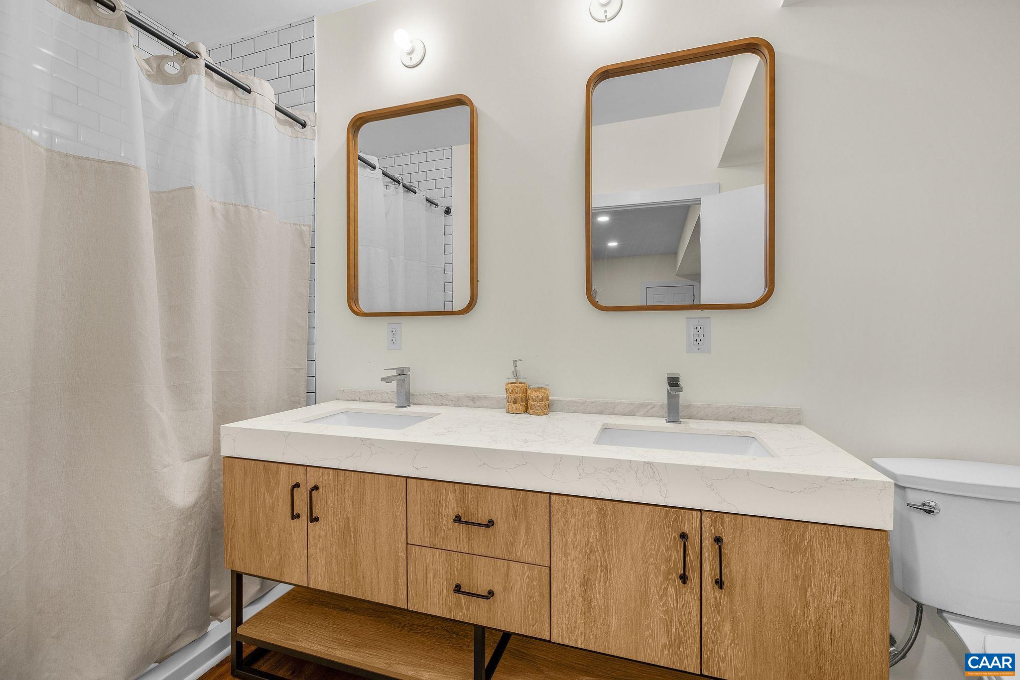Full bathroom with a double vanity and walk-in shower in the basement. Full bathroom with a double vanity and walk-in shower in the basement.