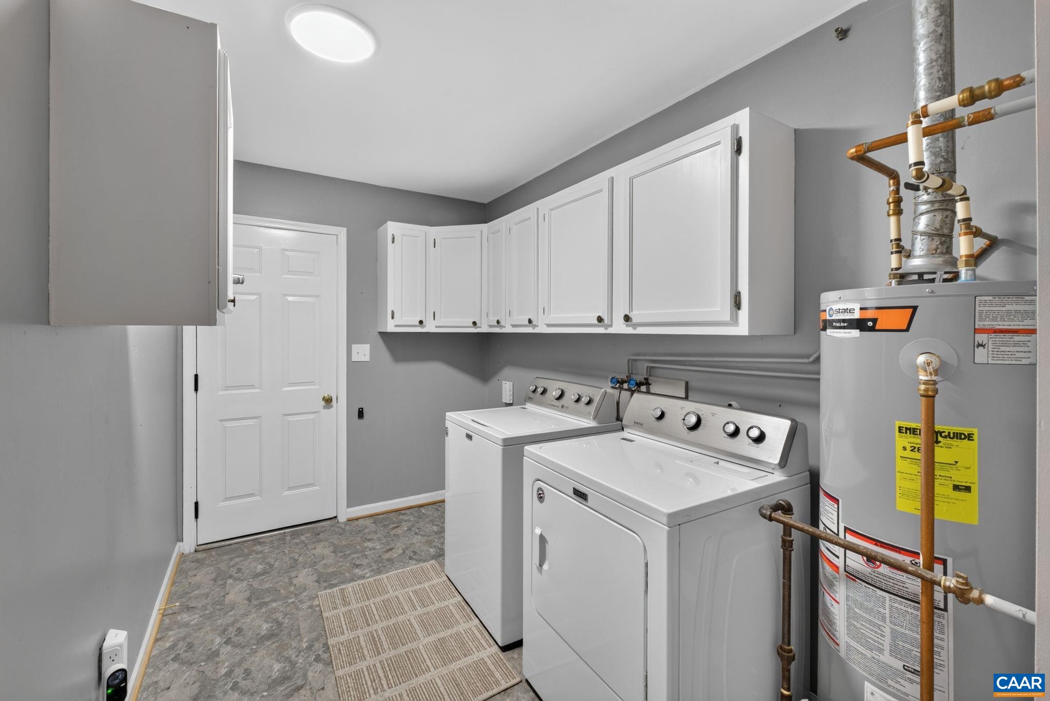 Laundry room has cabinetry + broom closet helping to keep everything perfectly organized