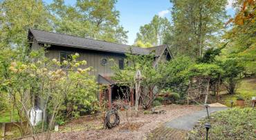 This home offers two parking lots. The top offers ample space and a walkway down to the front door through an arbor at the top of the stairs.