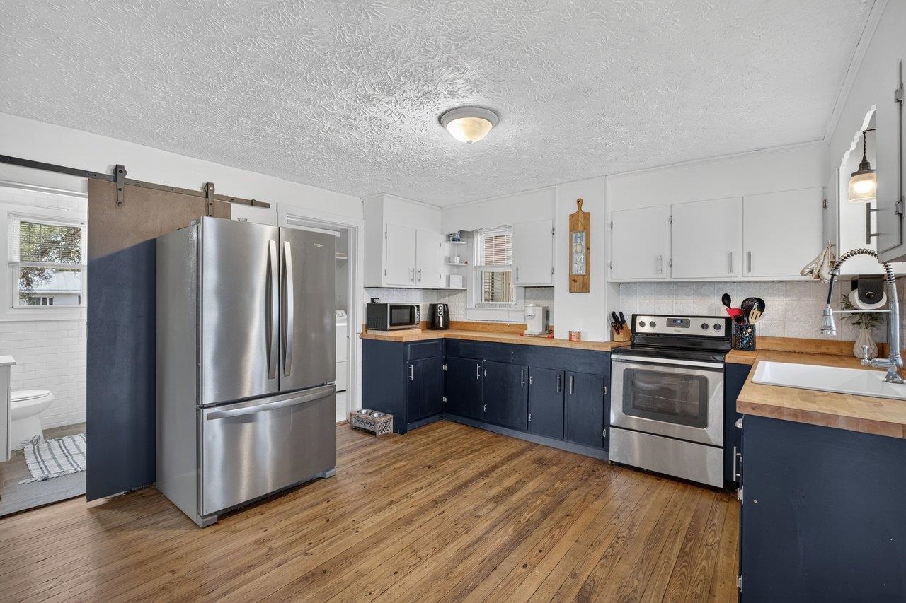 Fresh, inviting kitchen featuring painted cabinets, butcher block countertops, and stainless appliances. Fresh, inviting kitchen featuring painted cabinets, butcher block countertops, and stainless appliances.