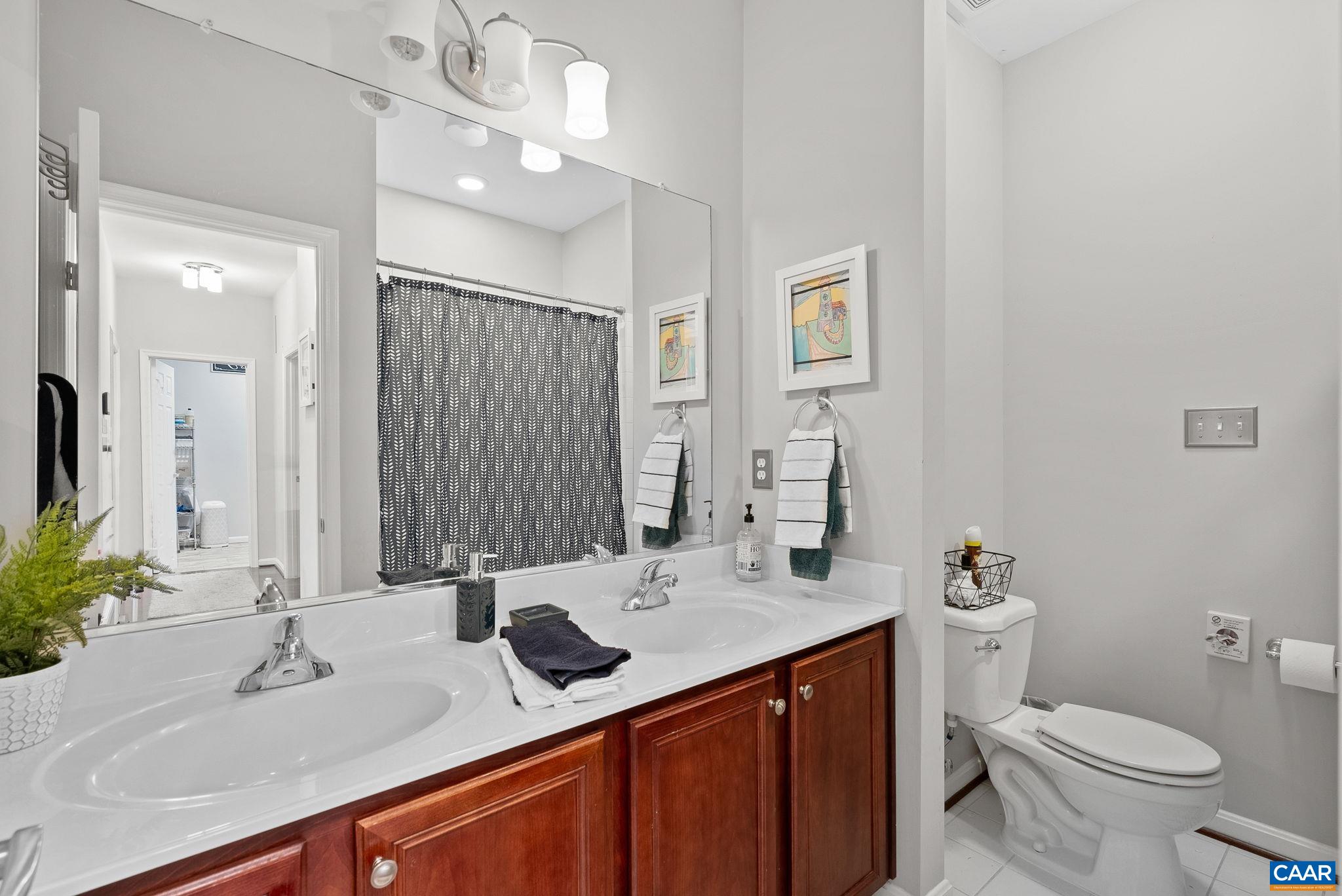 Double sinks oversized mirror with a seating area to get ready for the day. Double sinks oversized mirror with a seating area to get ready for the day.