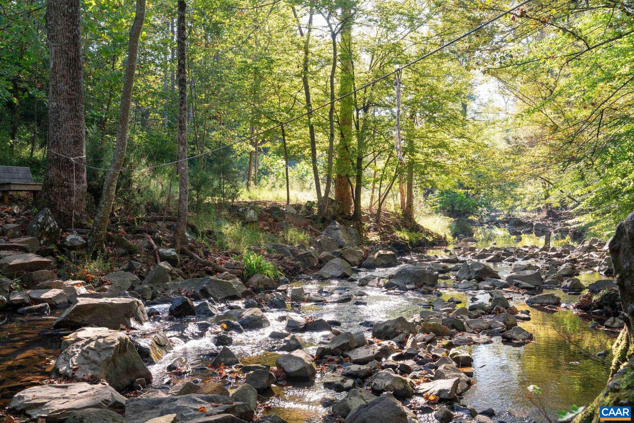 Pictured directly behind the home: Meadow Creek and the Rivanna River Trail, accessible from the property. The area shown is not part of the property offered for sale. Pictured directly behind the home: Meadow Creek and the Rivanna River Trail, accessible from the property. The area shown is not part of the property offered for sale.