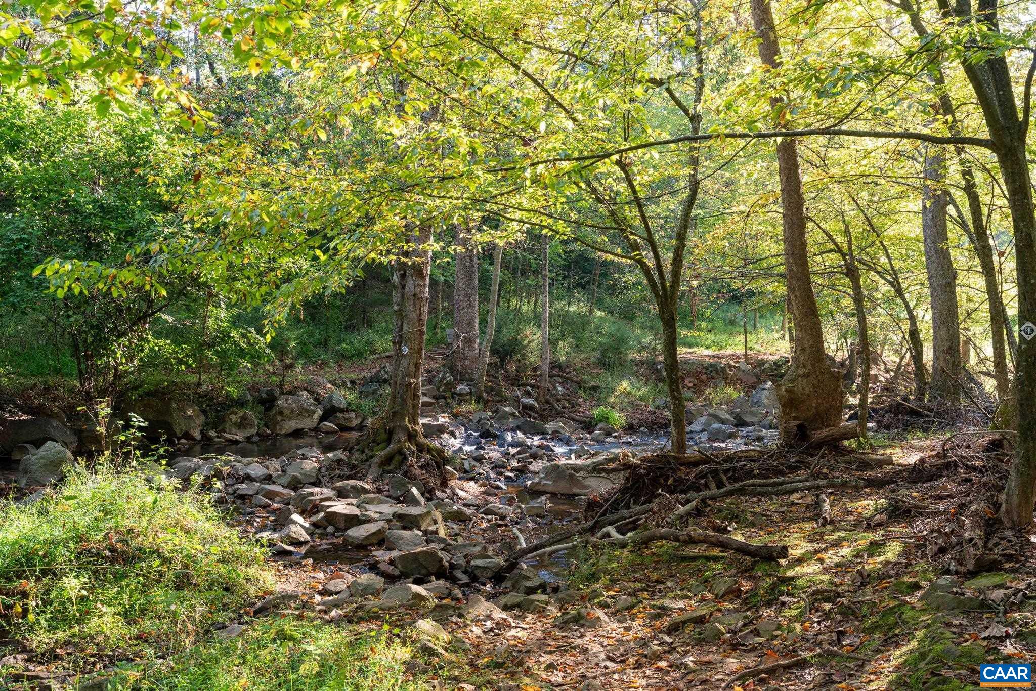 Pictured directly behind the home: Meadow Creek and the Rivanna River Trail, accessible from the property. The area shown is not part of the property offered for sale. Pictured directly behind the home: Meadow Creek and the Rivanna River Trail, accessible from the property. The area shown is not part of the property offered for sale.