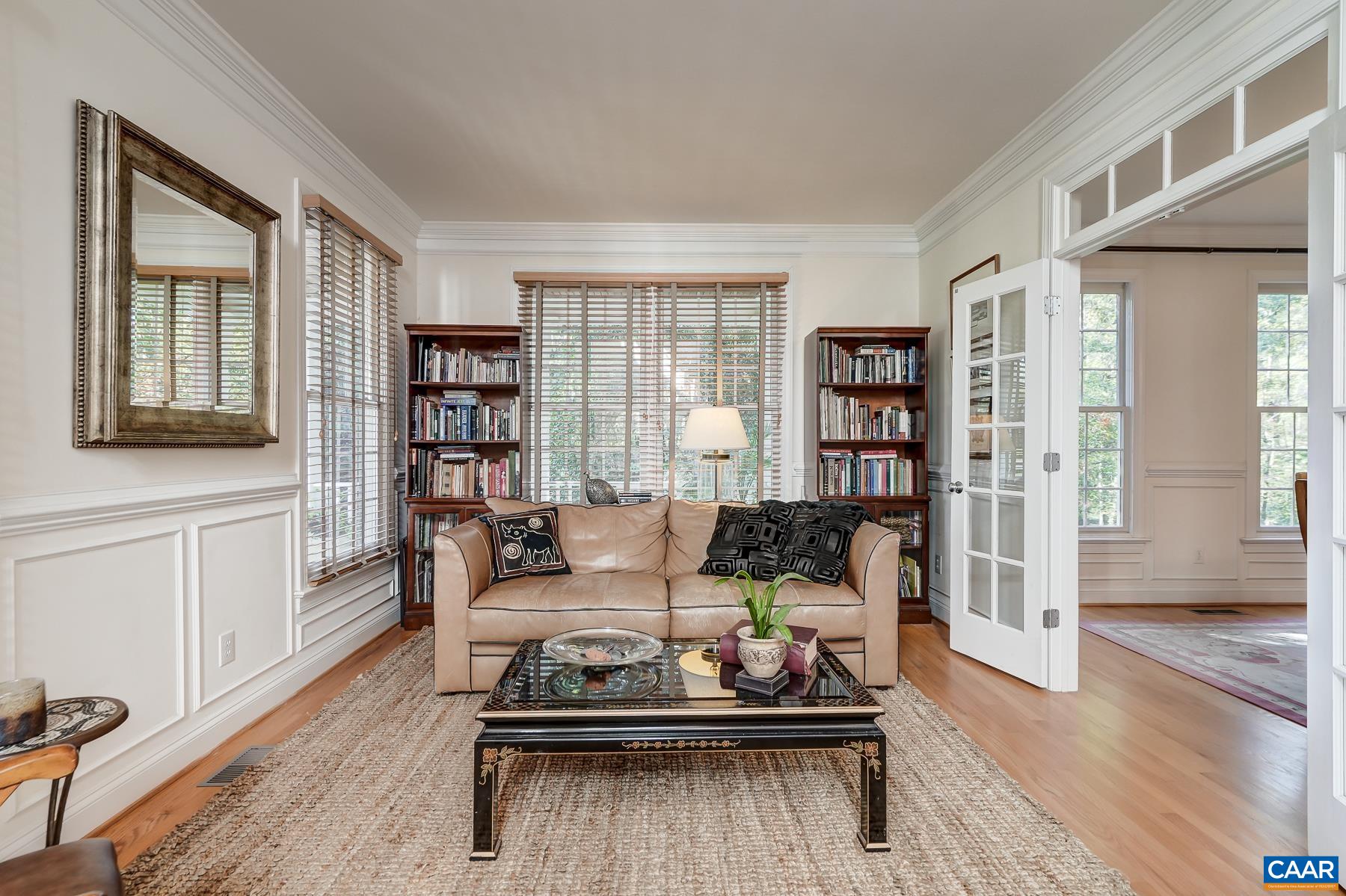Formal living room/study at the front of the home features wainscoting trim and french doors with transom to the dining room. Formal living room/study at the front of the home features wainscoting trim and french doors with transom to the dining room.