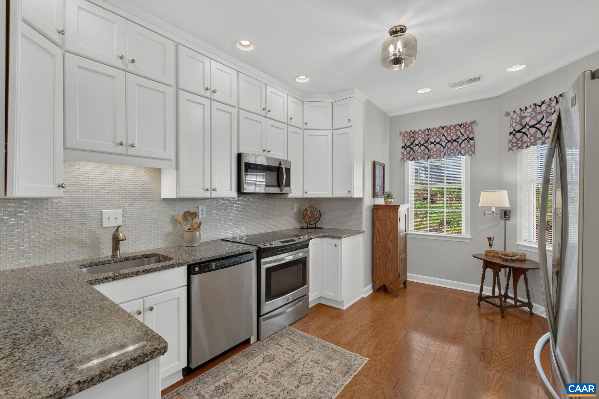 Tons of cabinet space in the kitchen that also features a stylish backsplash and granite counters. Tons of cabinet space in the kitchen that also features a stylish backsplash and granite counters.