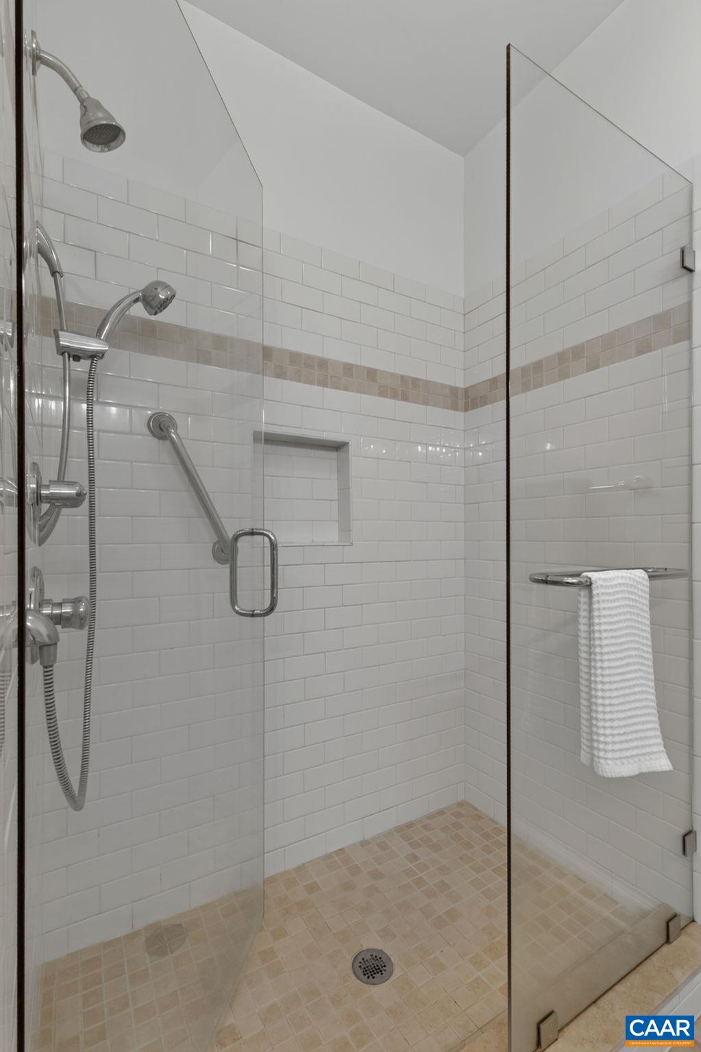 Spacious tiled shower with glass door Spacious tiled shower with glass door