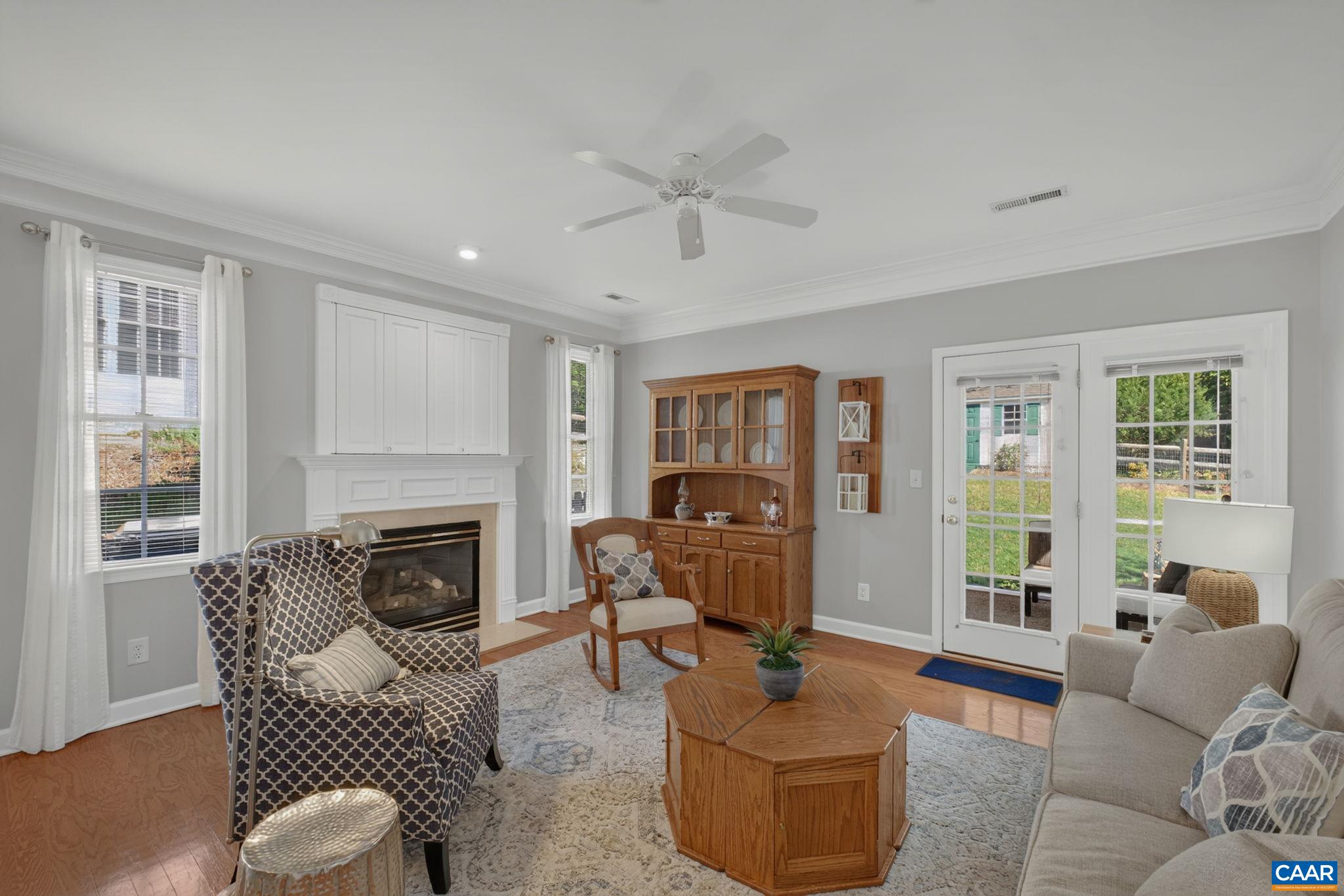 Cozy living room with wood floors, large windows for natural light, and french doors that open onto the screened in porch. Cozy living room with wood floors, large windows for natural light, and french doors that open onto the screened in porch.