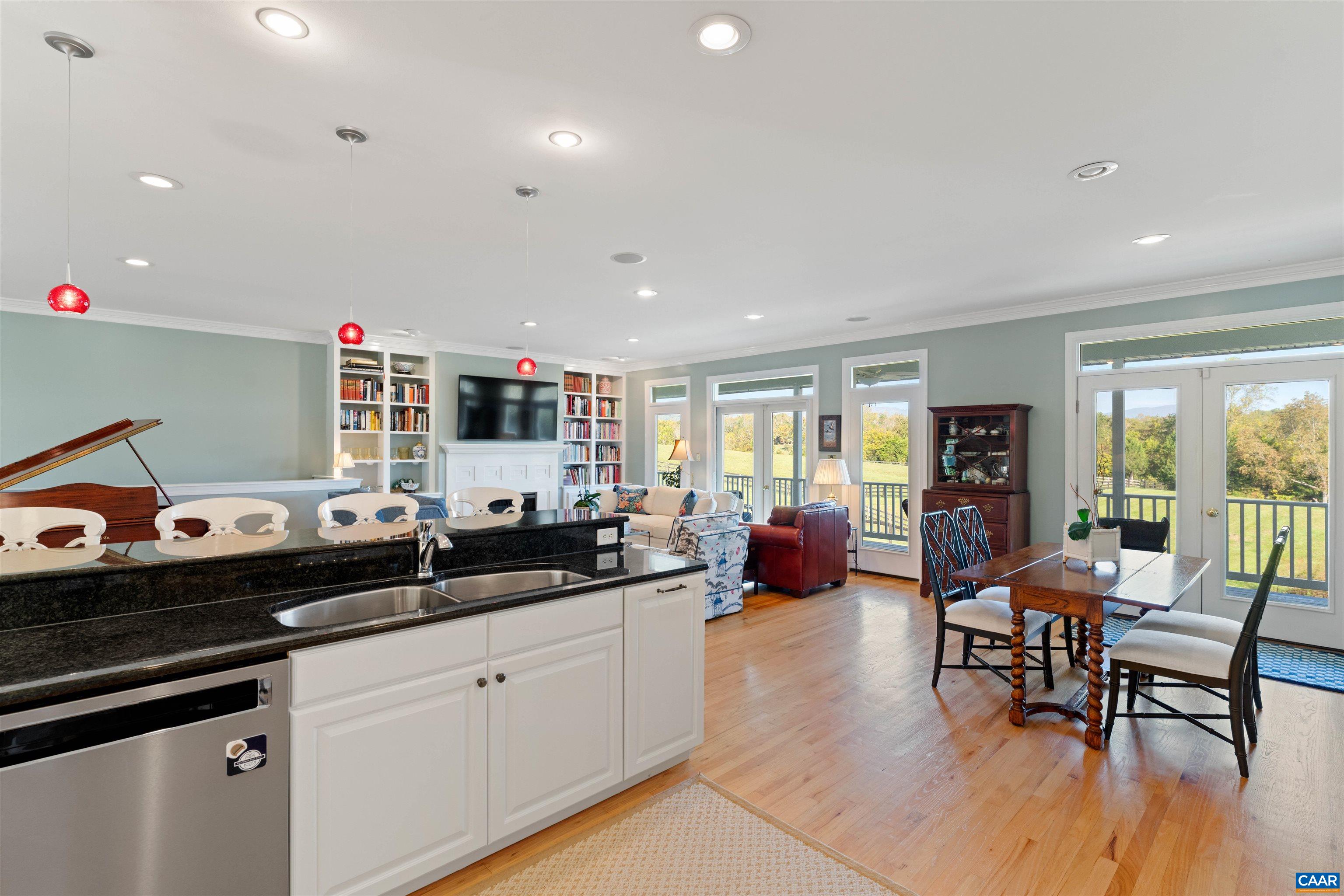 The kitchen opens to the breakfast area and the living room, with island seating and views through the porch doors. The kitchen opens to the breakfast area and the living room, with island seating and views through the porch doors.