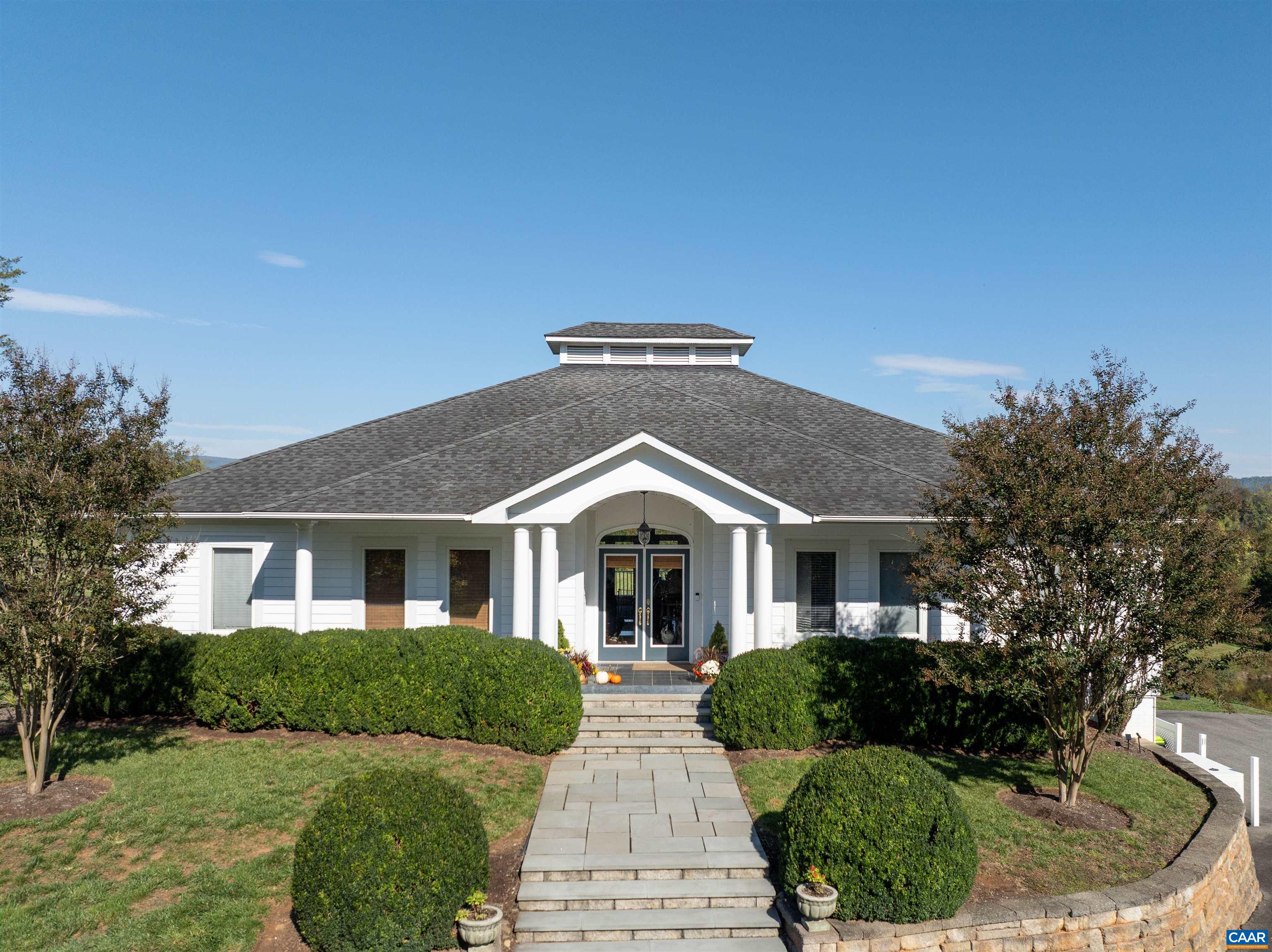 The front of the 2005 residence designed by Bob Anderson: columned entry portico, flagstone steps and walkway, and a stone-edged arrival court. The front of the 2005 residence designed by Bob Anderson: columned entry portico, flagstone steps and walkway, and a stone-edged arrival court.