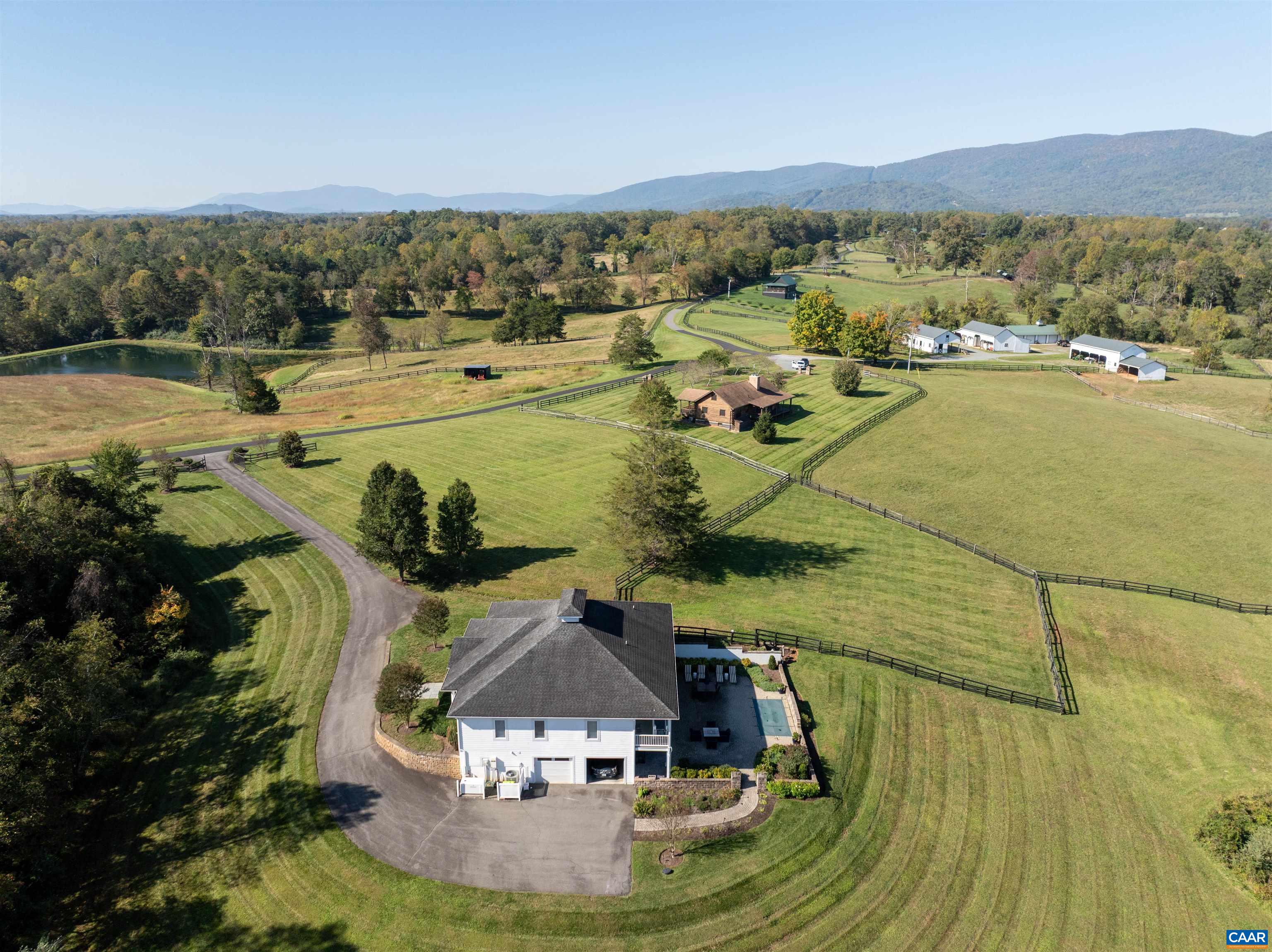 Aerial view of the rear of the residence and the walkout lower level, with the paddocks, cabin and barns beyond. Aerial view of the rear of the residence and the walkout lower level, with the paddocks, cabin and barns beyond.