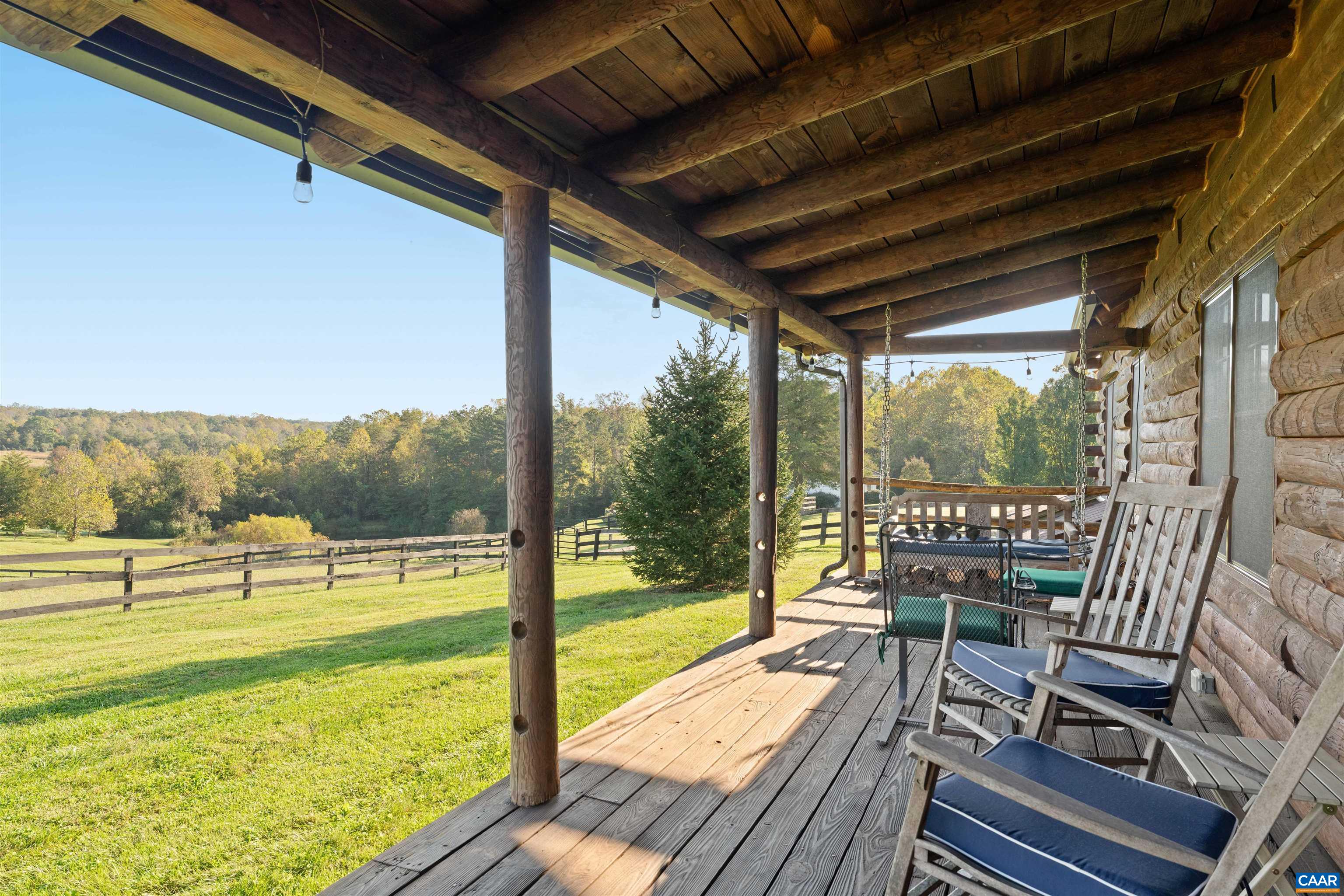 Covered porch along the cabin, overlooking the paddocks and woodland. Covered porch along the cabin, overlooking the paddocks and woodland.