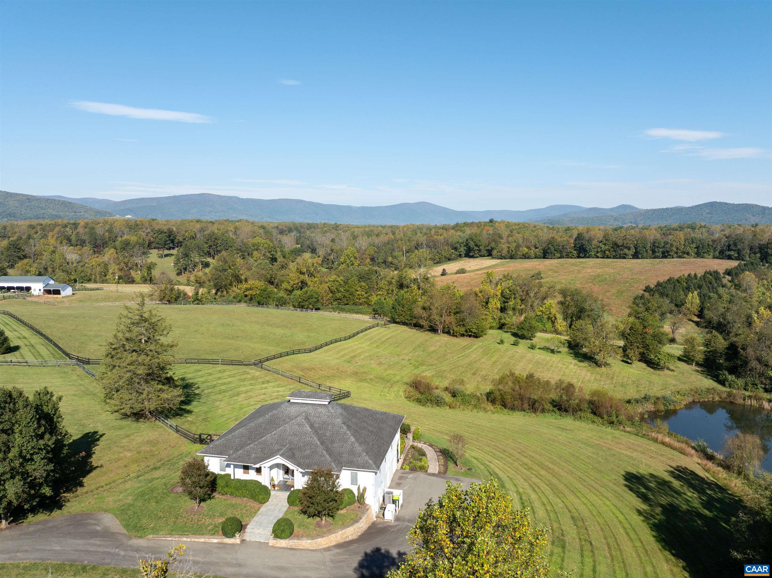 Aerial view of the main residence on open, board-fenced pasture, with the pond to the right and the Blue Ridge on the horizon. 108 acres at the end of a private paved road between Ivy and White Hall. Aerial view of the main residence on open, board-fenced pasture, with the pond to the right and the Blue Ridge on the horizon. 108 acres at the end of a private paved road between Ivy and White Hall.