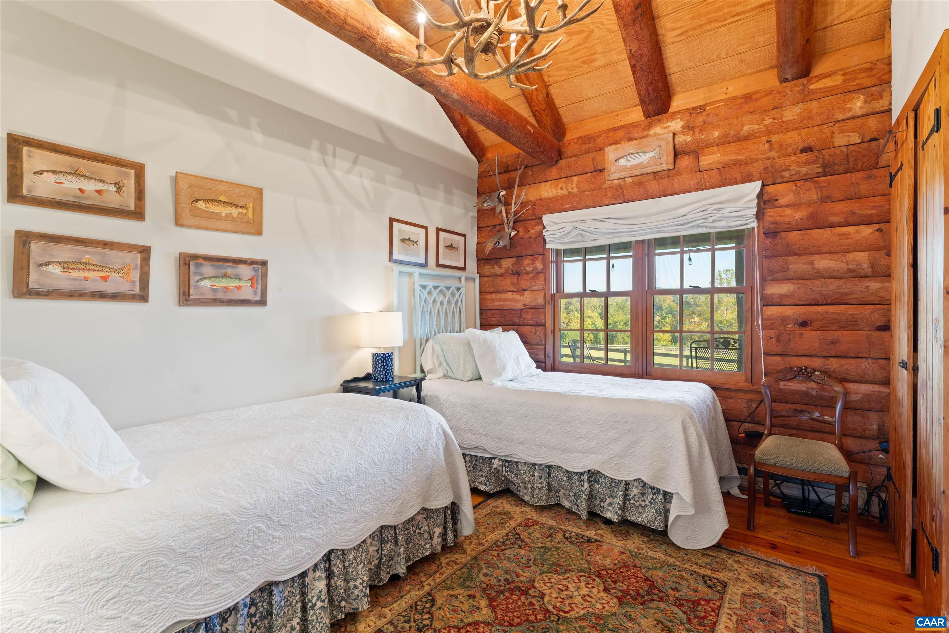 Second cabin bedroom with beamed ceiling and pasture views. Second cabin bedroom with beamed ceiling and pasture views.