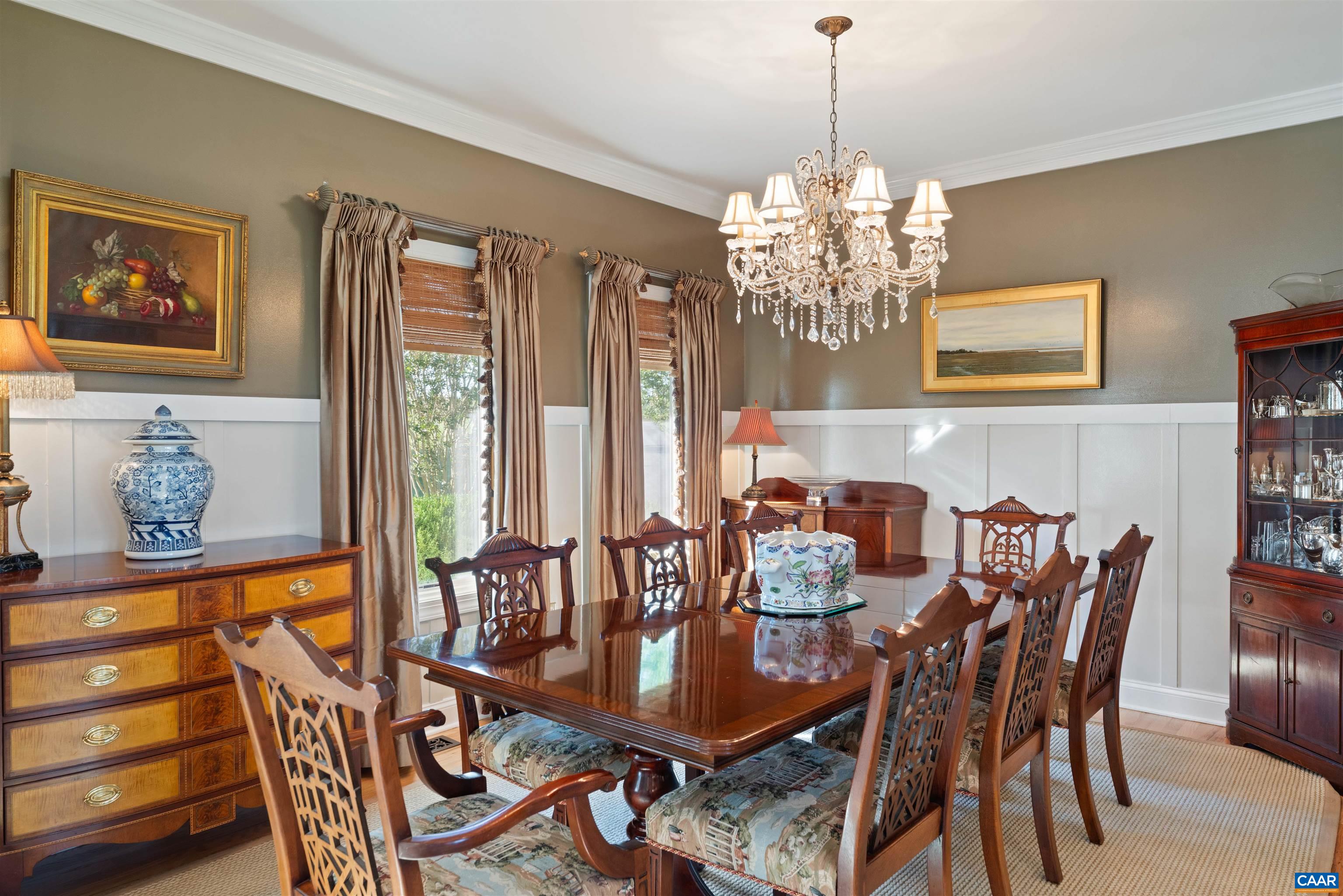 Formal dining room with wainscoting, crown molding and garden views. Formal dining room with wainscoting, crown molding and garden views.
