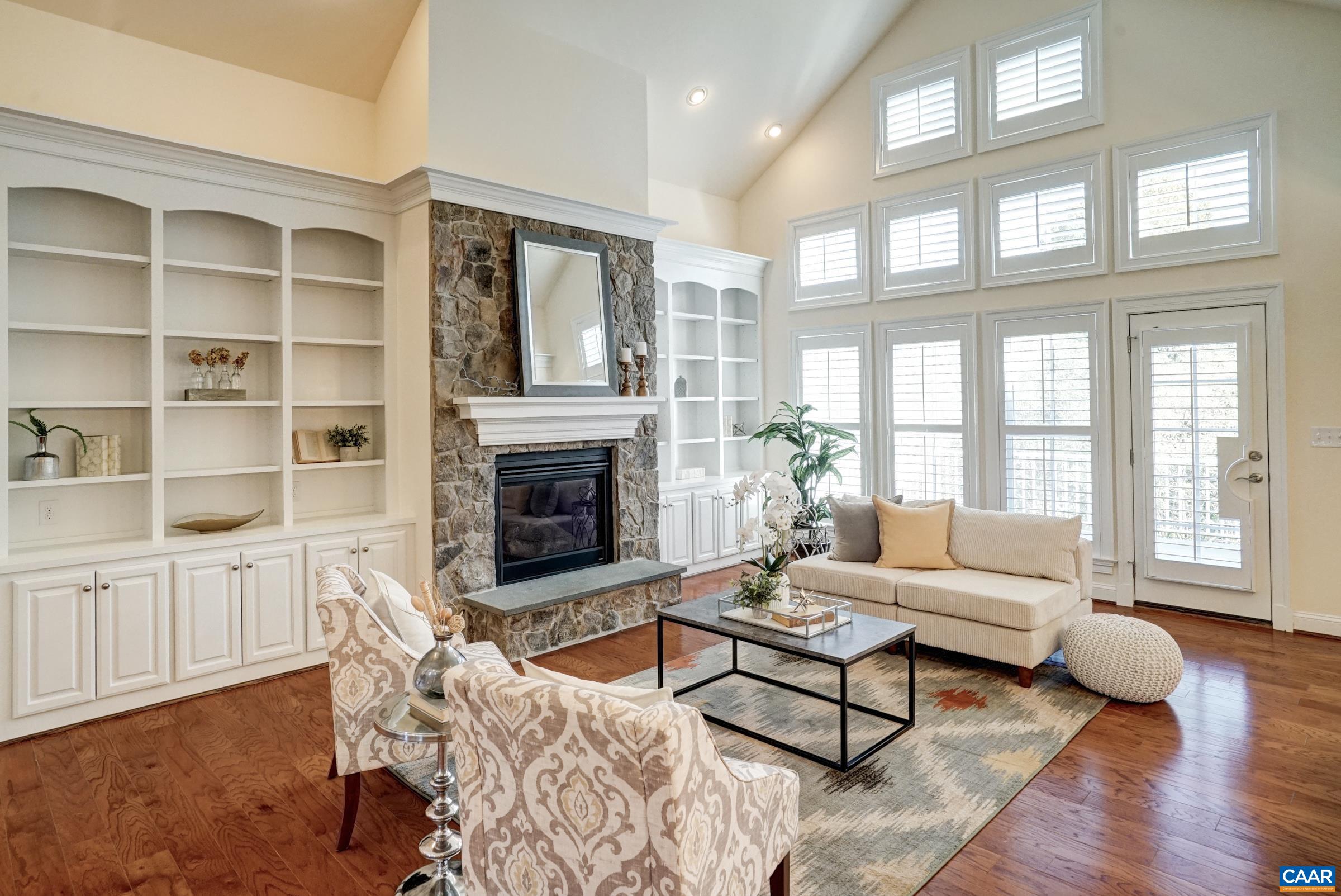 Gas fireplace with stone accent wall flanked by built-in shelves and storage cabinets. Gas fireplace with stone accent wall flanked by built-in shelves and storage cabinets.
