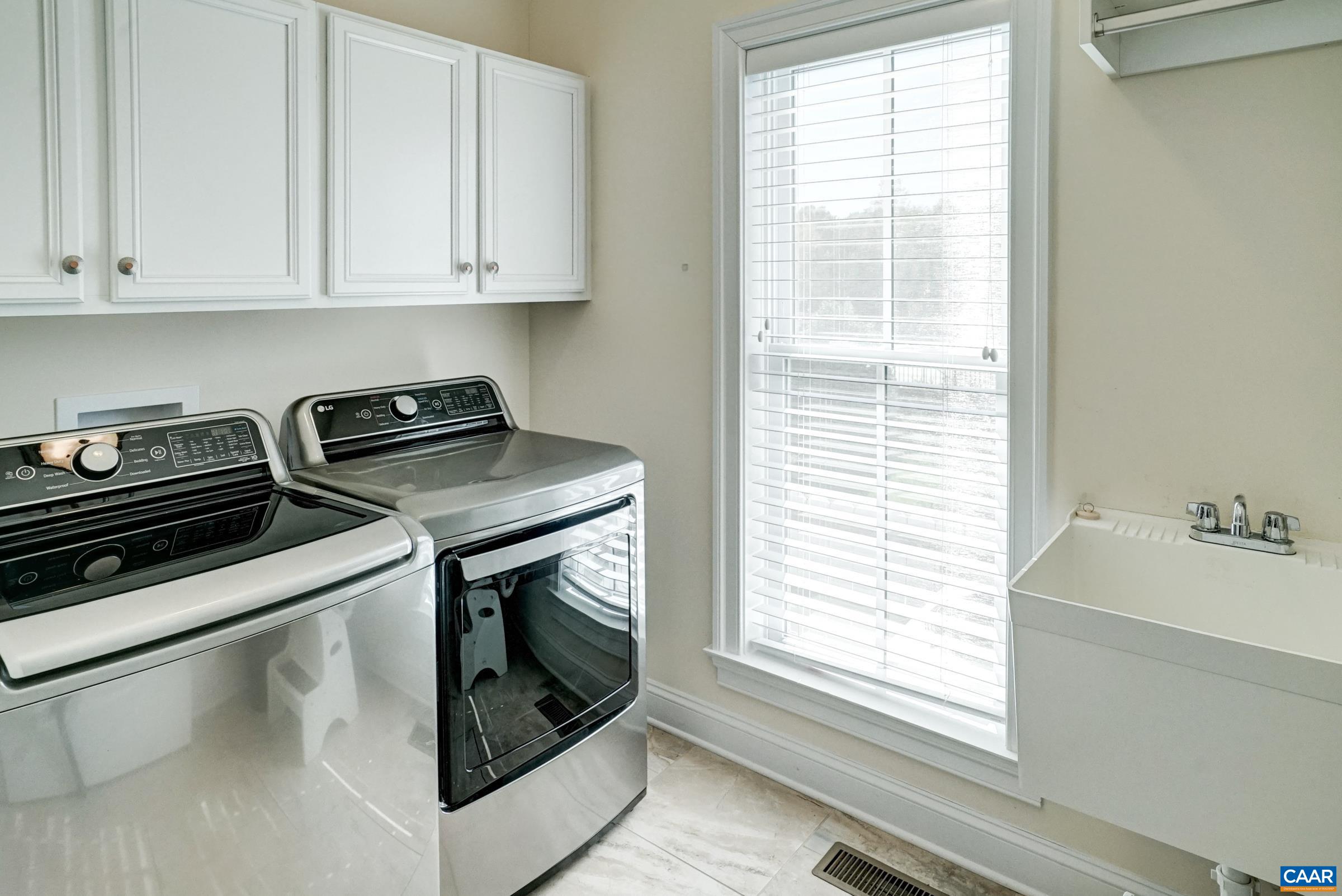 Large laundry room with storage and utility sink. Large laundry room with storage and utility sink.