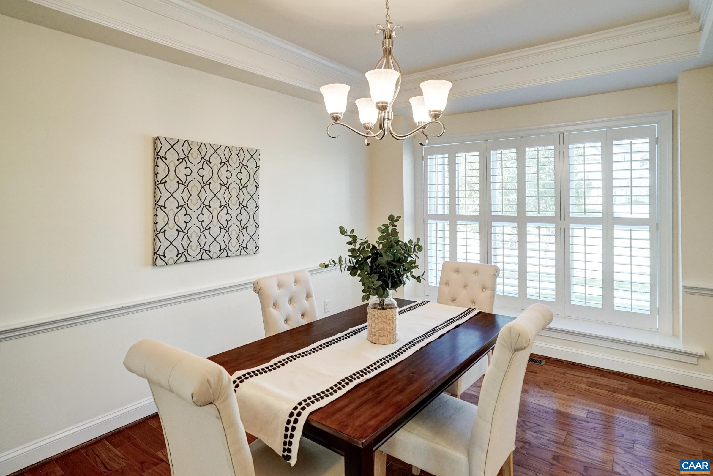 Formal dining room features tray ceiling with crown moulding and chair rail. Formal dining room features tray ceiling with crown moulding and chair rail.