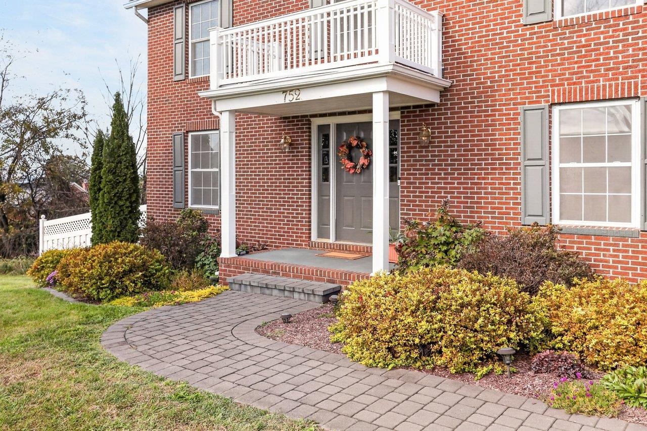 The inviting entry features a paver walkway leading to a welcoming front porch.