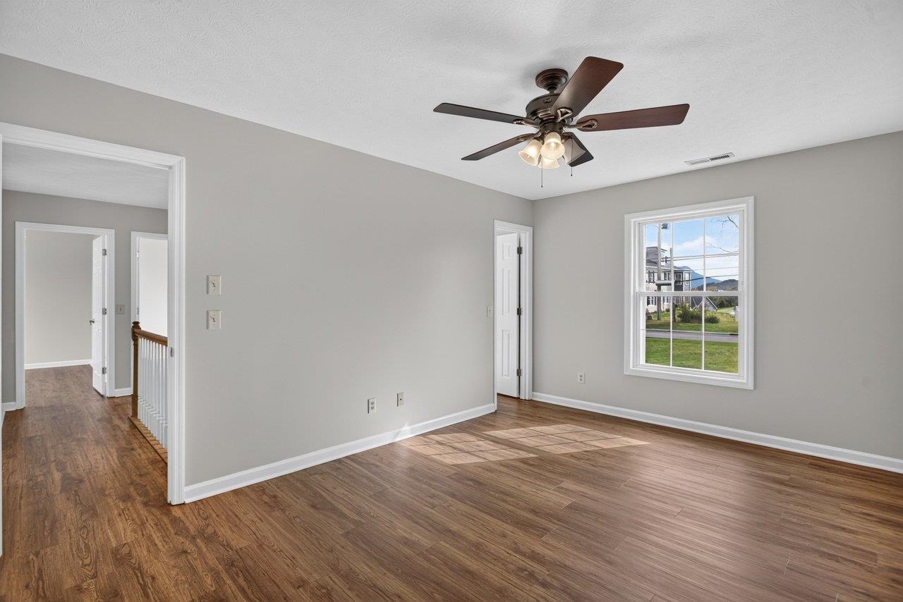 The primary bedroom features LVP flooring, a spacious walk-in closet, a ceiling fan, and a private bath.