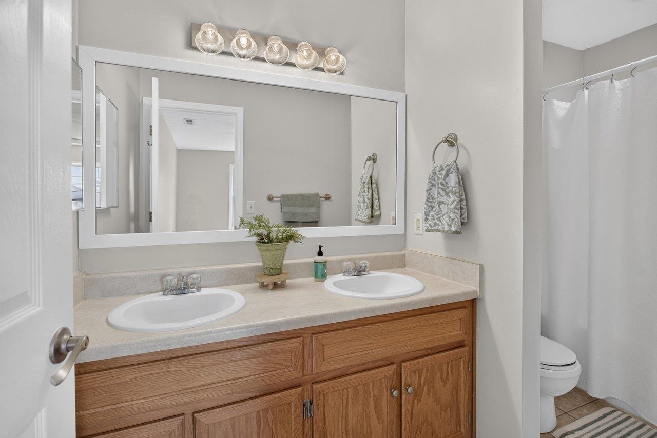 The primary bath features double sinks, tile flooring, and a tub/shower combination.