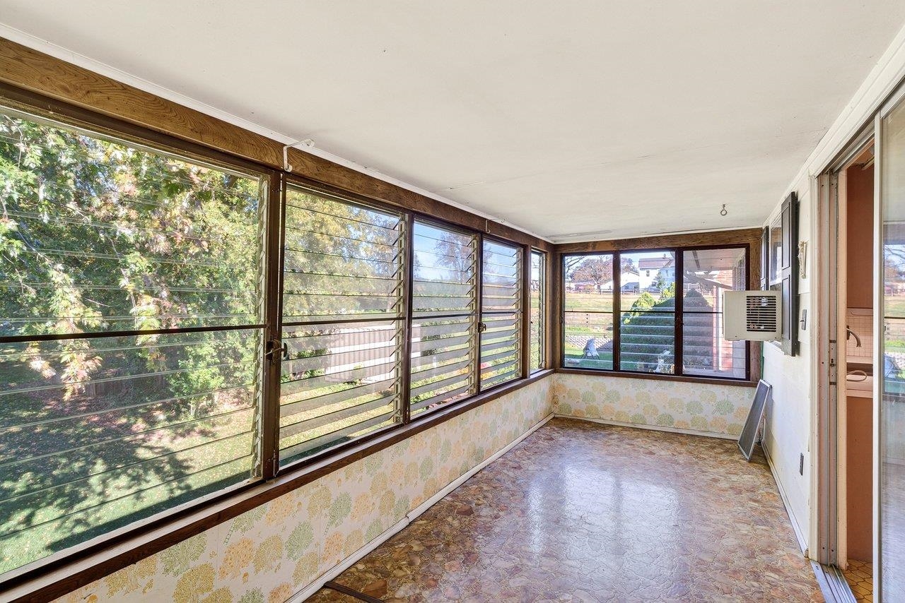 The enclosed sun porch provides extra living space and a great spot to enjoy views of the spacious backyard.