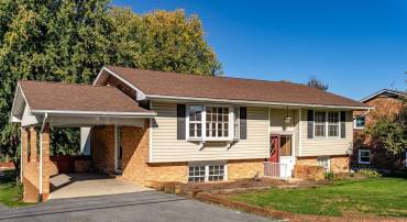 This split foyer home features low-maintenance brick and vinyl siding, along with a convenient one-car carport and paved driveway.