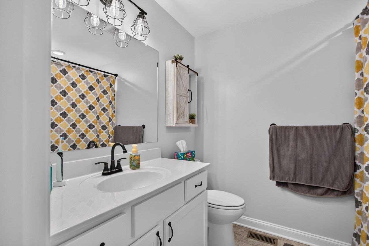 The private primary bath features a spacious white vanity and tub/shower combination.