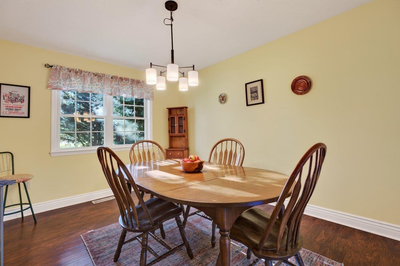 The bright and cheerful dining room offers plenty of space for a nice-sized table and features new luxury vinyl plank flooring.
