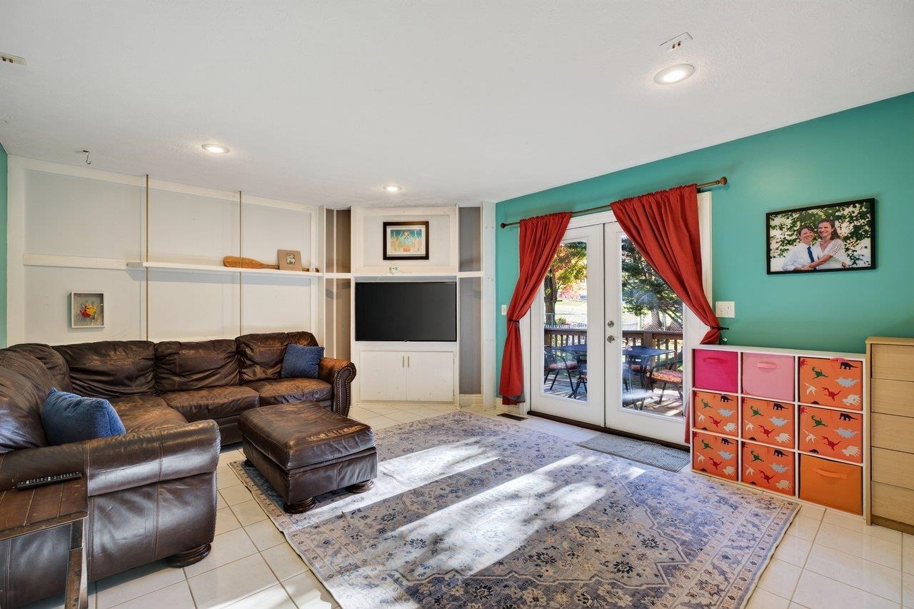 The spacious family room features easy-care tile flooring, built-in shelving, and a corner TV cabinet. A door opens to the deck, making it easy to enjoy the backyard.