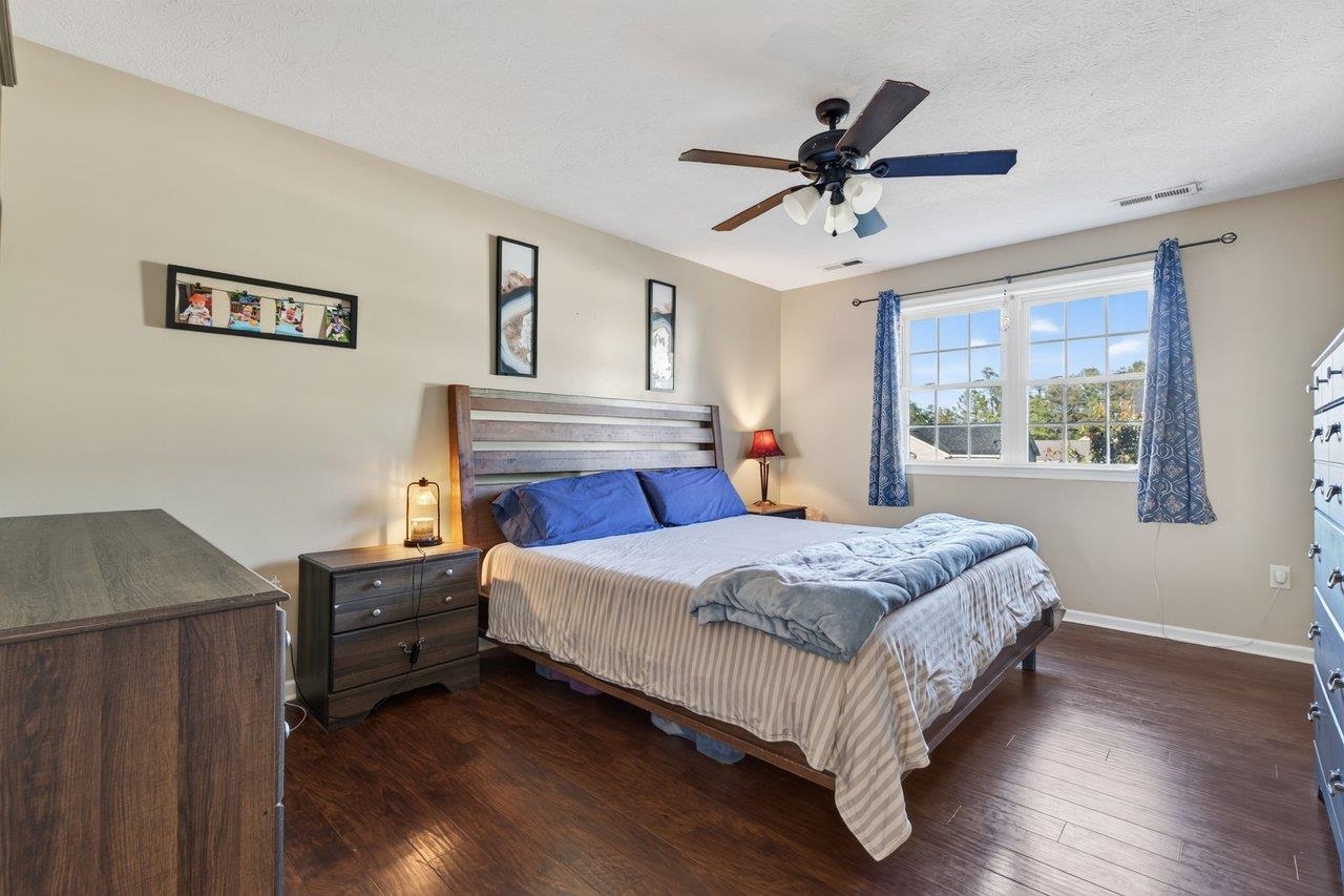 The primary bedroom features new luxury vinyl plank flooring, a ceiling fan, a walk-in closet, and a private bath.
