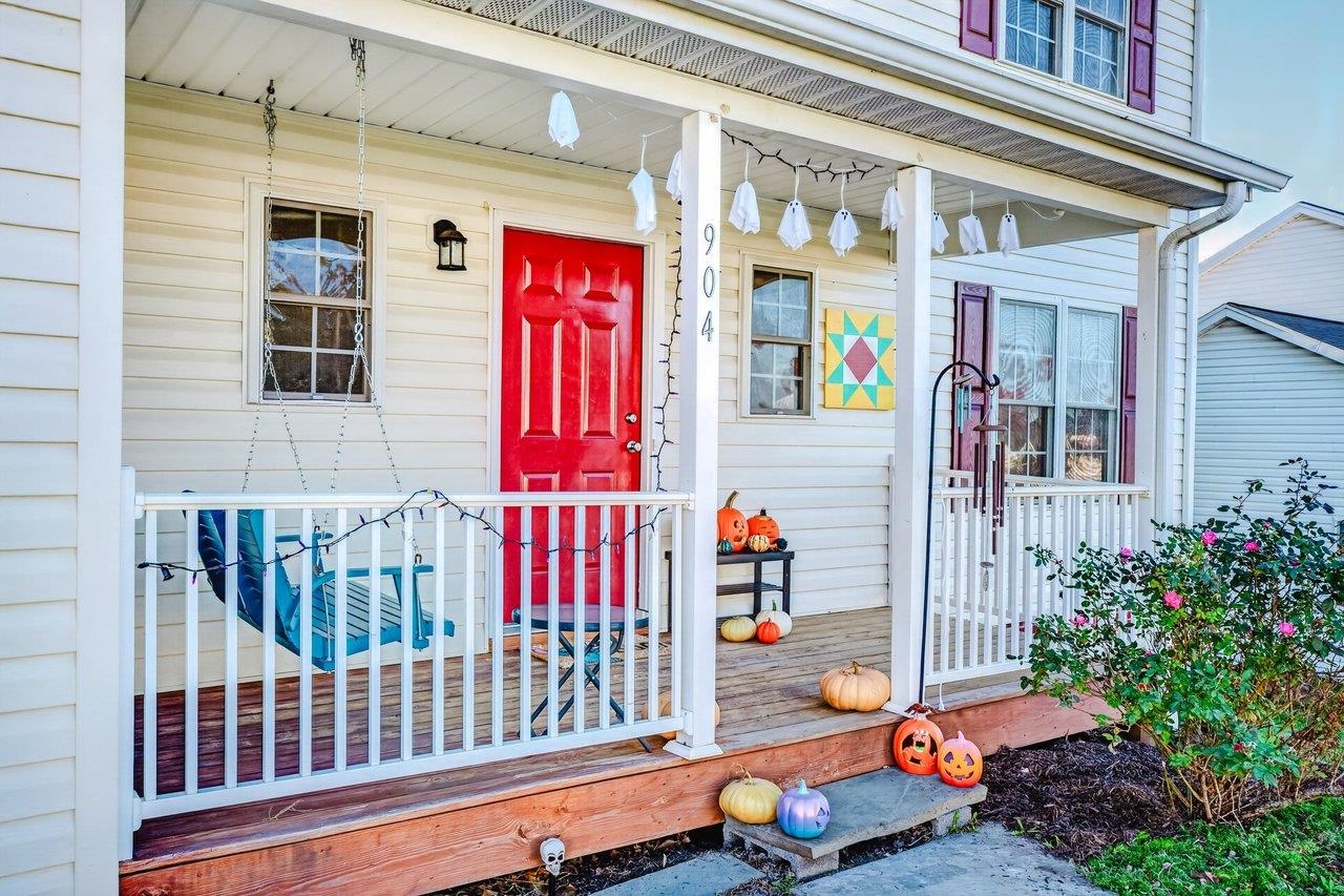 The front porch features wood flooring with vinyl railings and columns for a clean, attractive look.