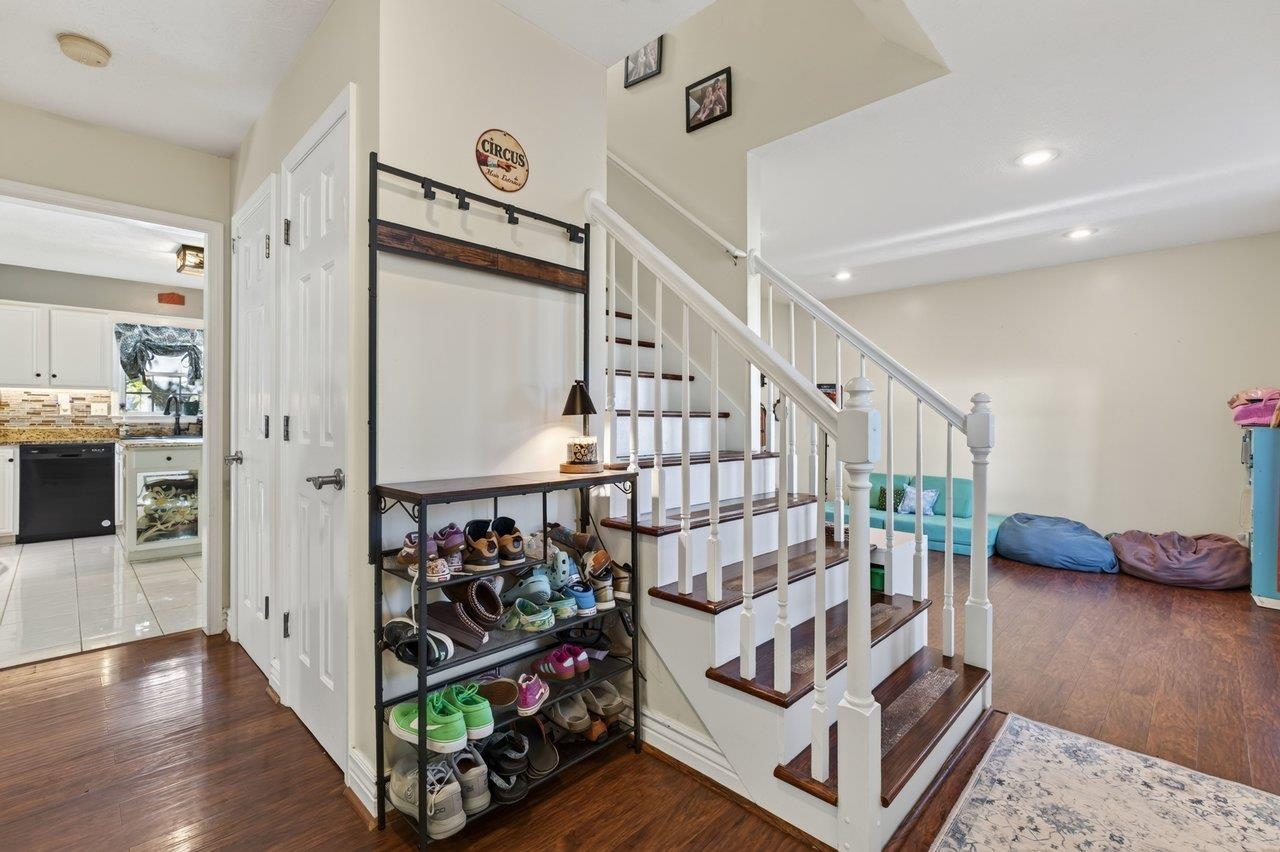 The front entry hall opens directly to the living room, currently used as a playroom, and the kitchen.