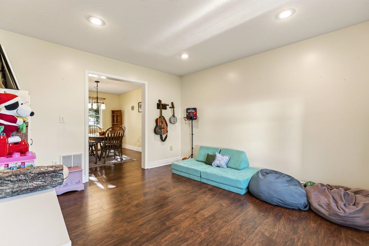 The living room features new luxury vinyl plank flooring and is currently being used as a children's playroom.