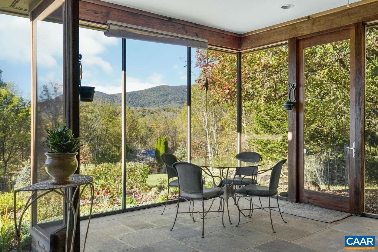 Four-seasons sunroom with full-length glass sliders opening to view with spa-like water gardens
