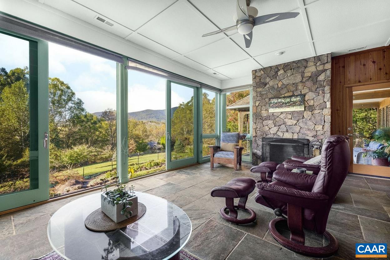 Four-seasons sunroom with full-length glass sliders opening to view with spa-like water gardens