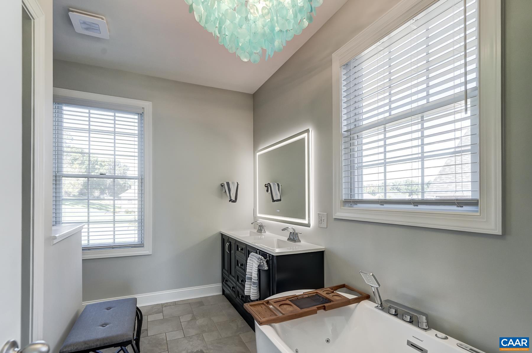 Primary bathroom with LED mirror, double sink vanity, and tile floor. Primary bathroom with LED mirror, double sink vanity, and tile floor.